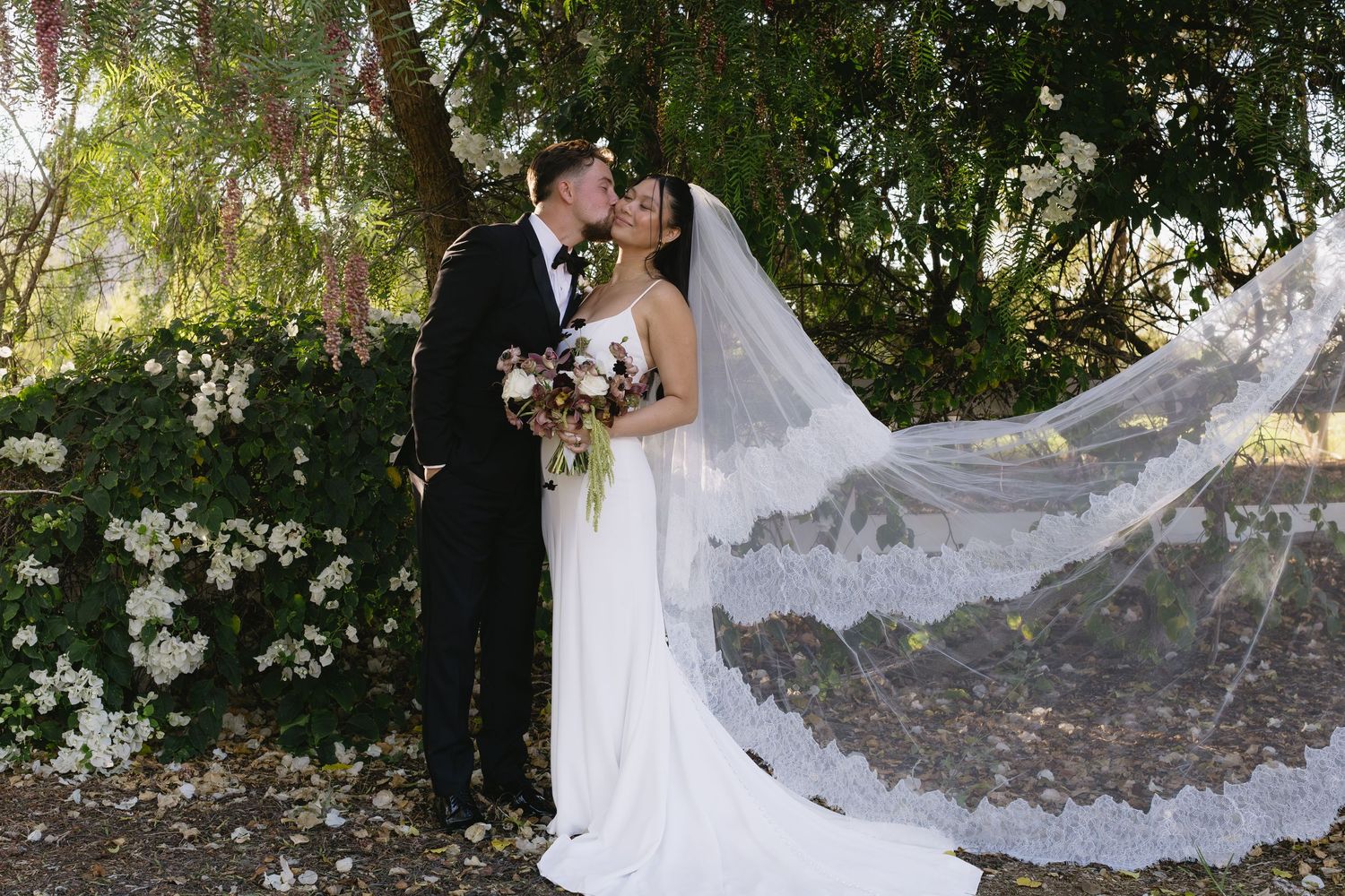 Elegant bridal veil flowing in the breeze during outdoor wedding portraits.