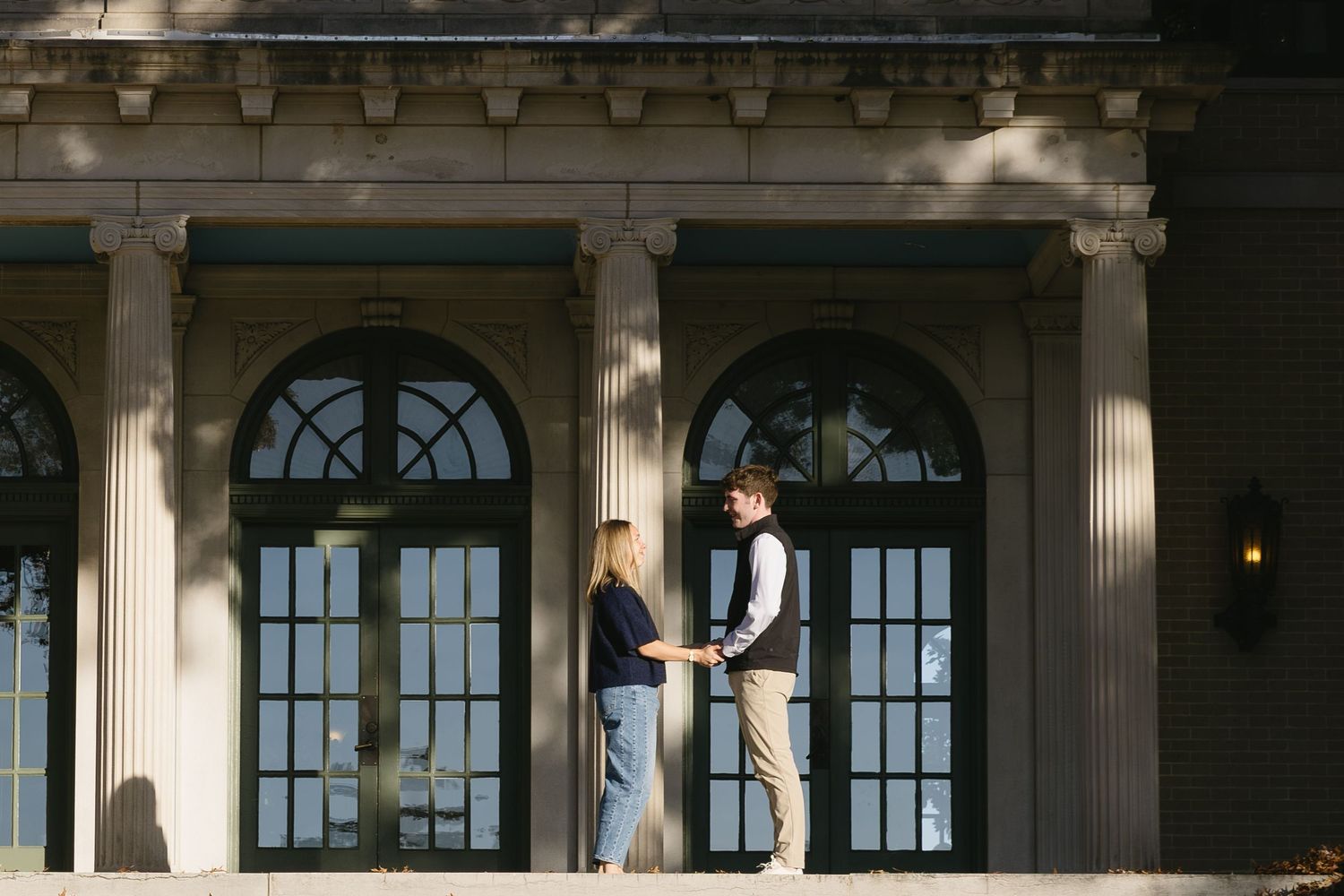 Architectural detail of columns and arched windows on a classical building facade.