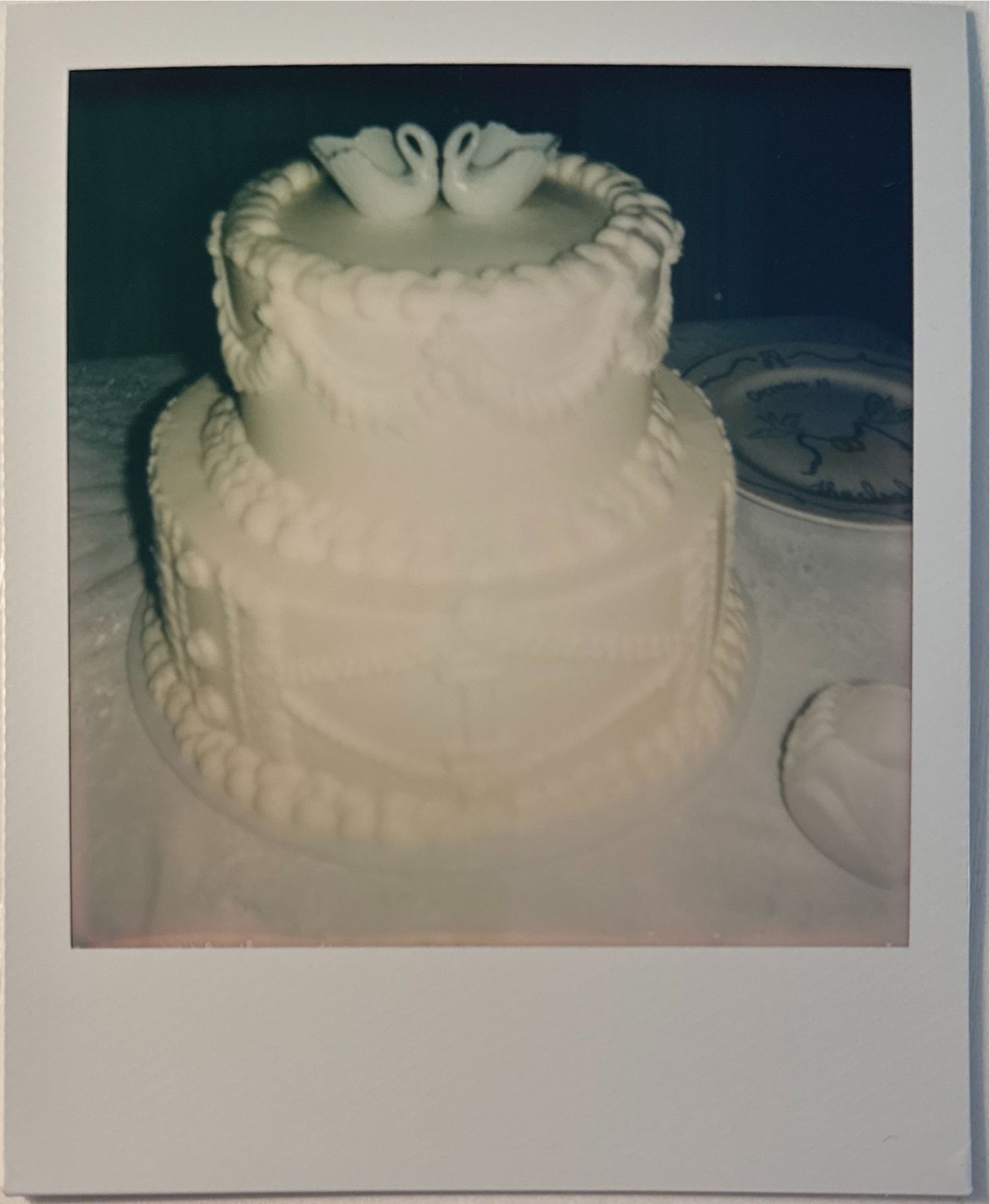 A series of vintage Polaroid photos showing a white frosted cake with decorative piping details.
