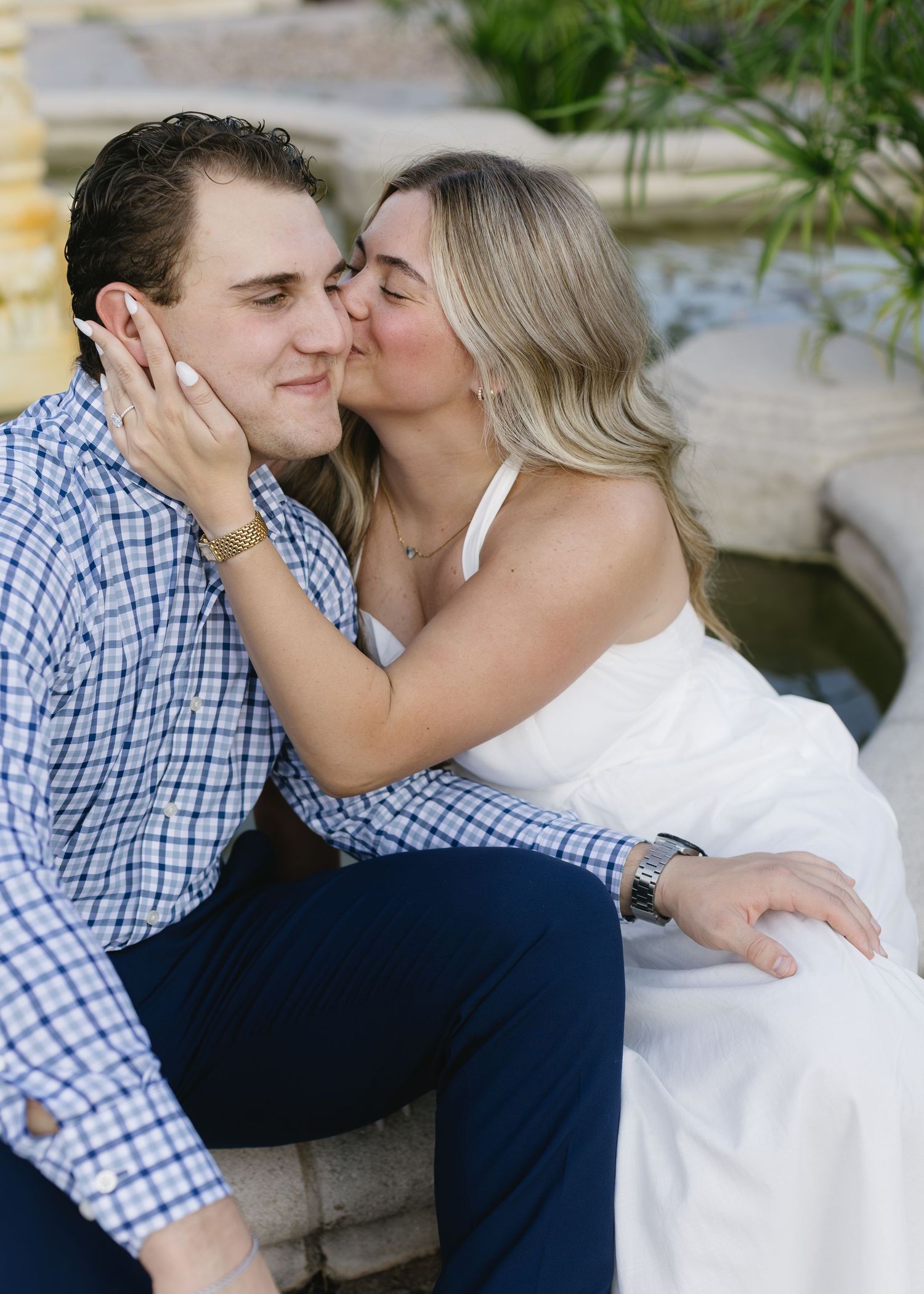 A romantic couple in blue plaid and white embraces in multiple sweet moments together outdoors.