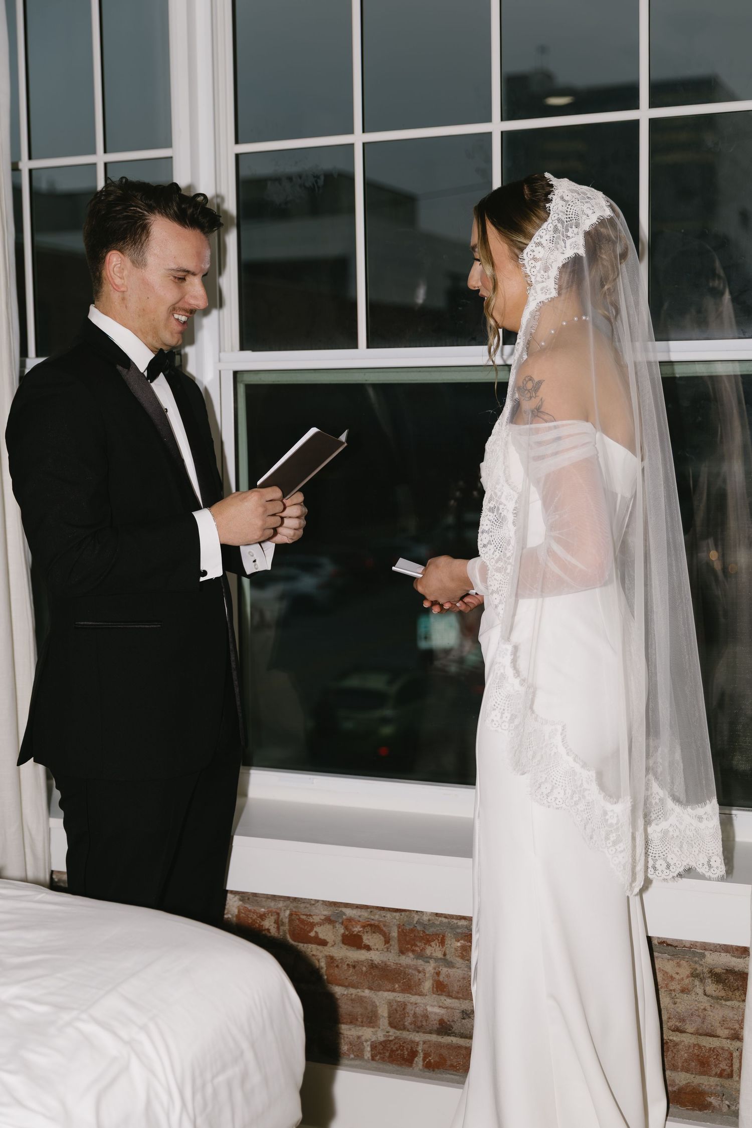 A first look wedding moment captured through a series of candid photographs by large windows.