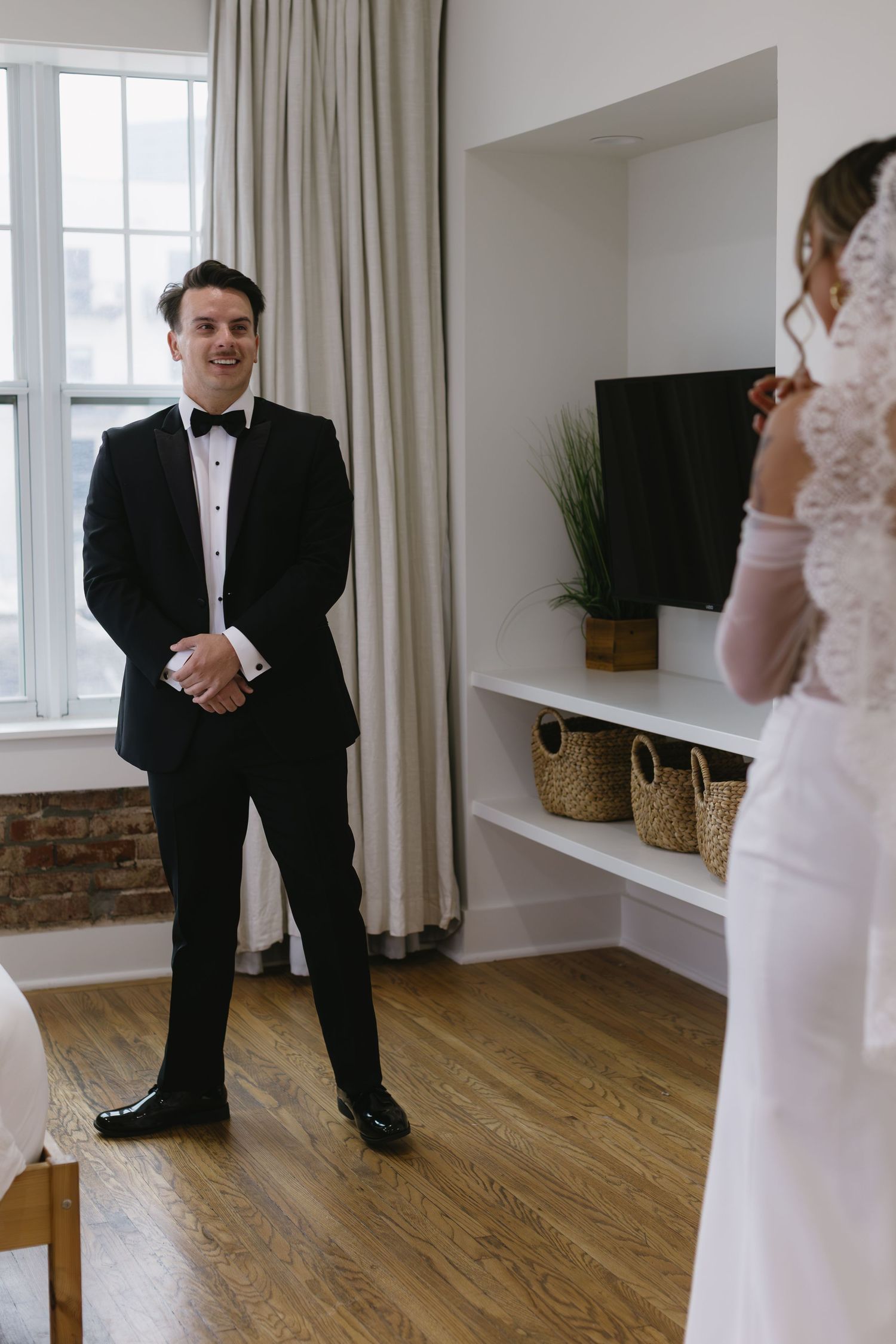 Bride and groom share their first look in an elegant room with natural lighting.