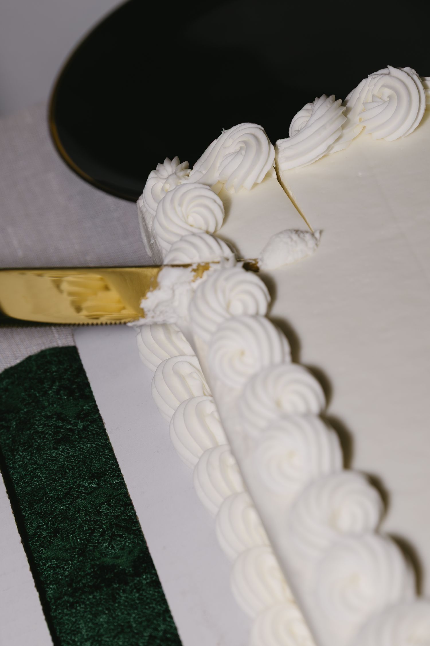 Close-up detail of white wedding cake frosting with delicate piped decorative patterns.