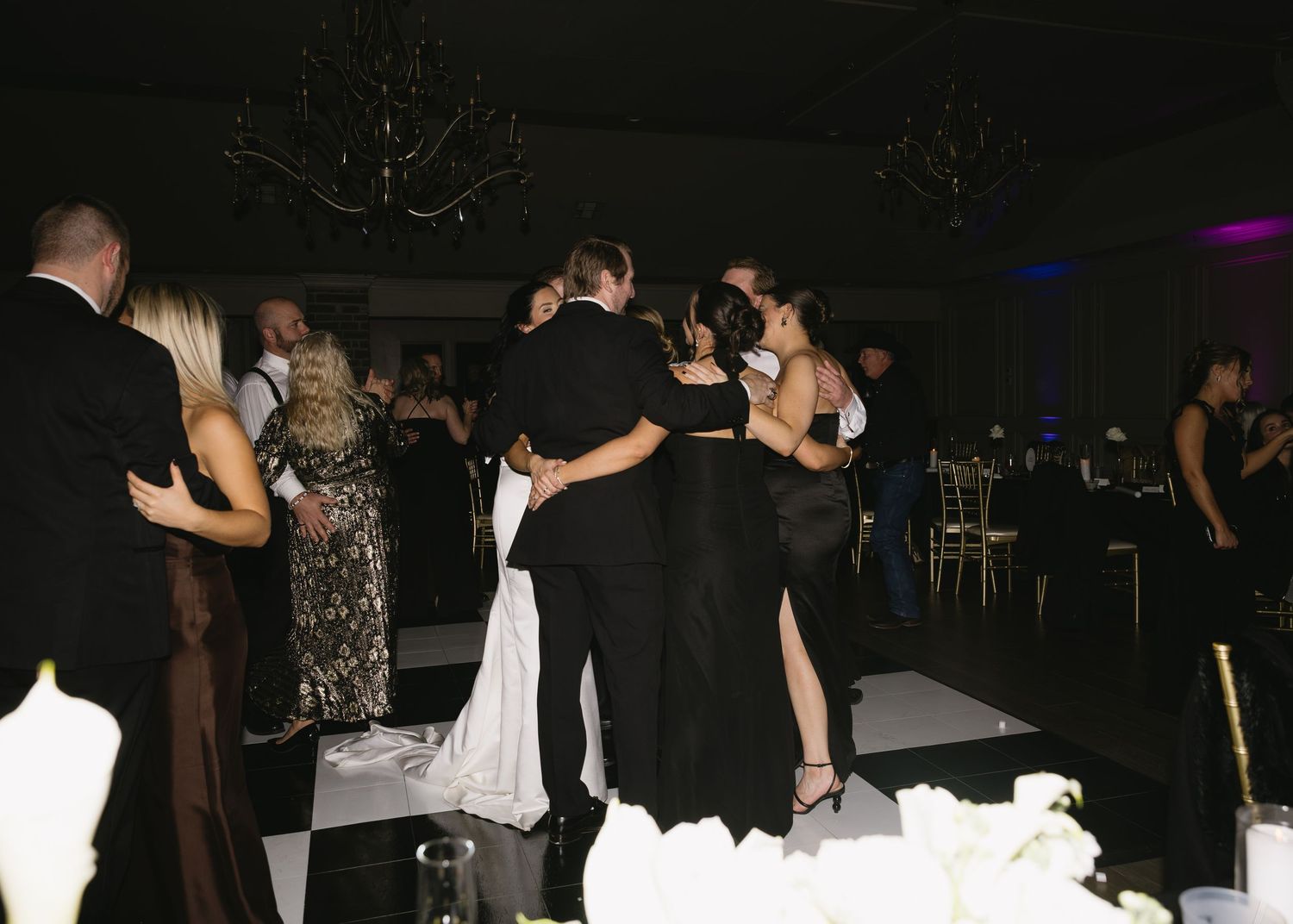 Couples slow dancing at an elegant evening wedding reception.