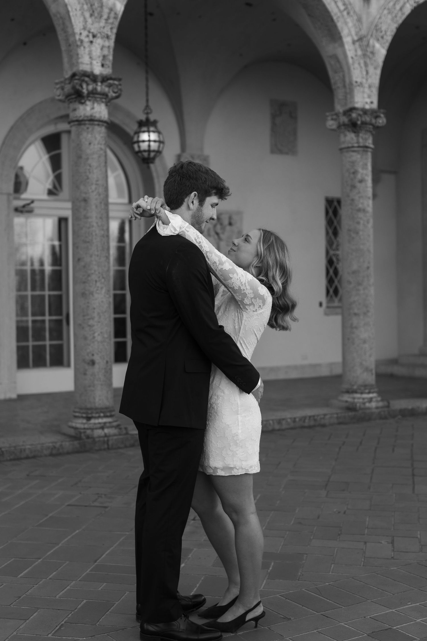 A romantic dance sequence in black and white under a columned archway.