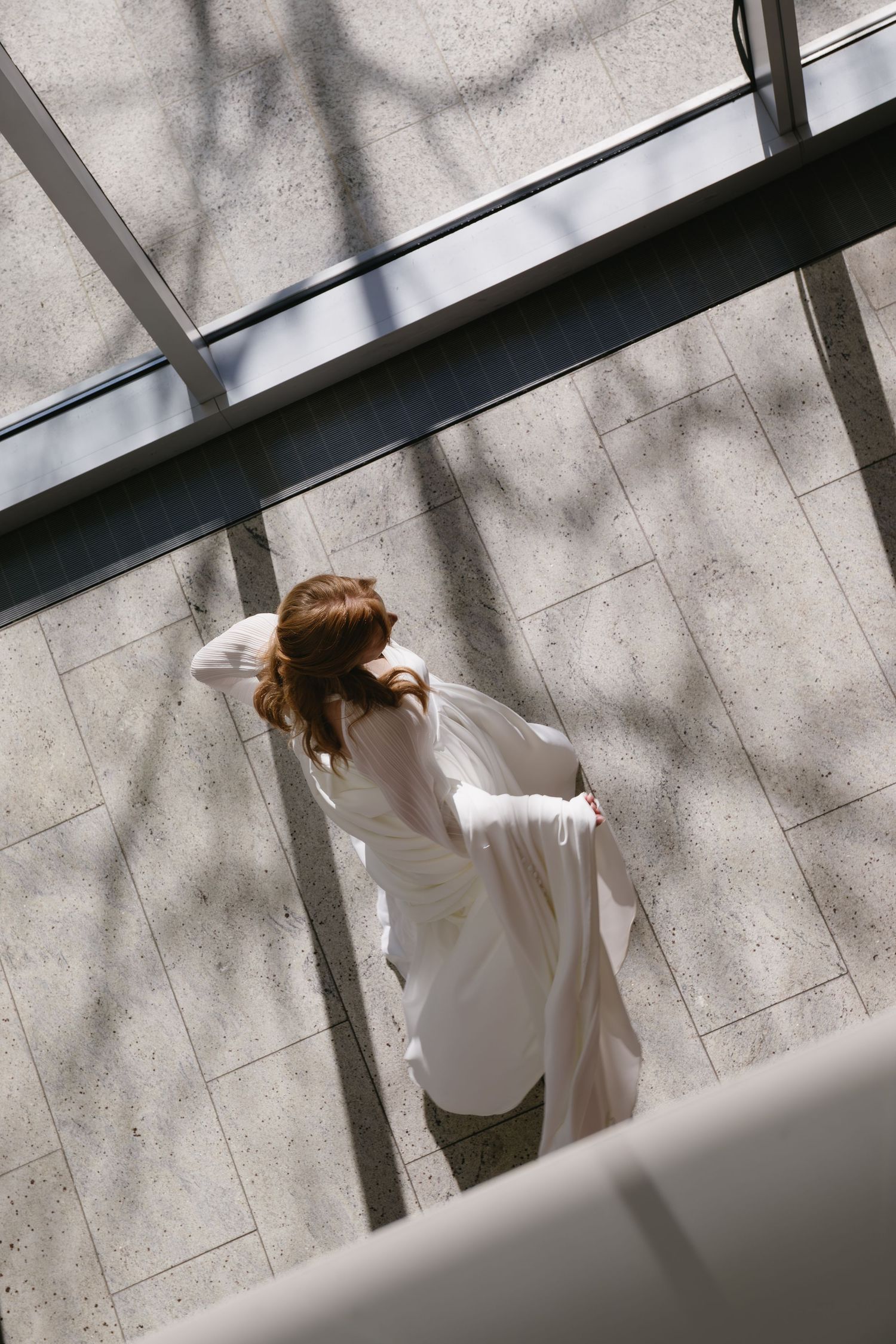 Artistic wedding photography showing shadows and light through windows on concrete walls.