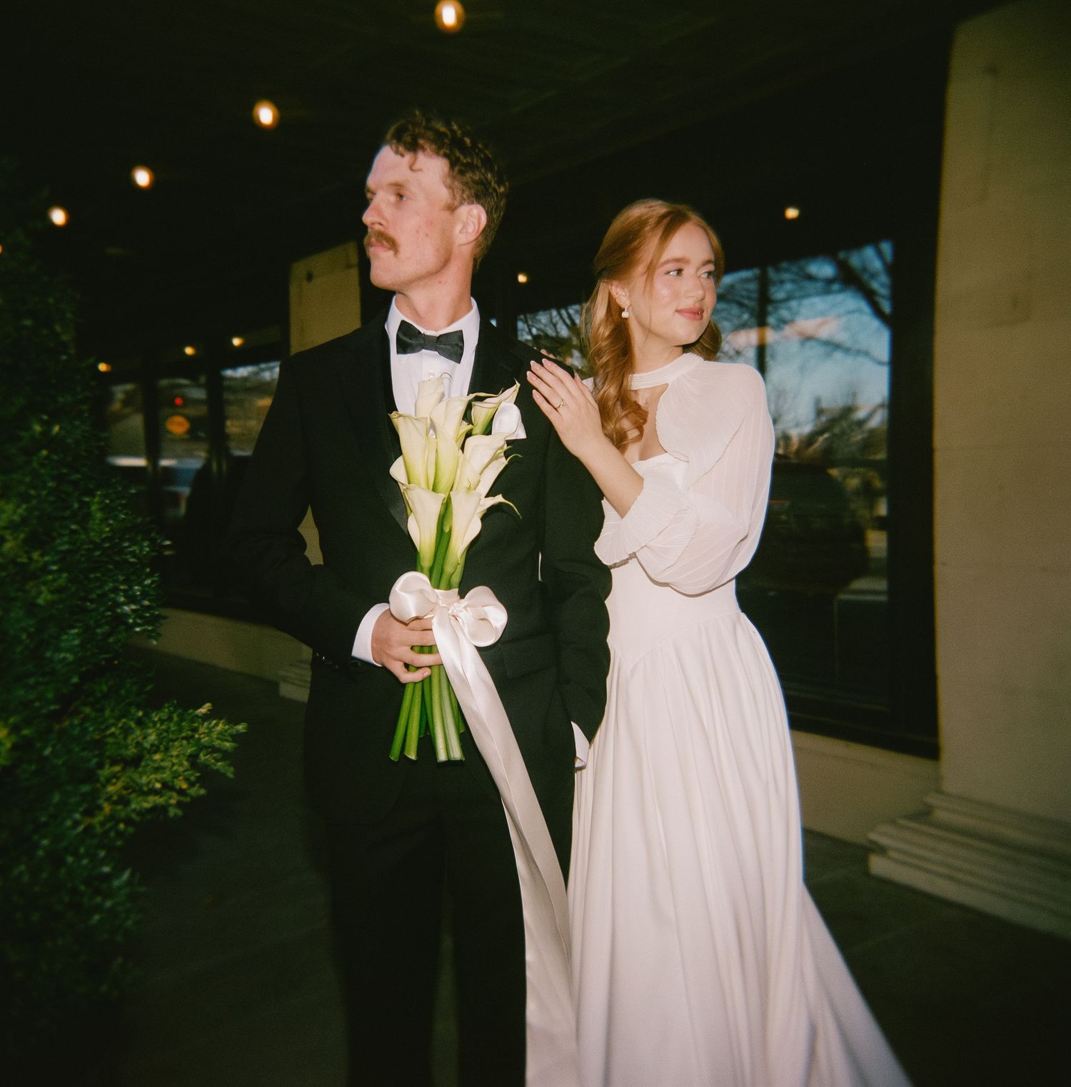 Nighttime wedding photos with couples in formal attire and white flowers.