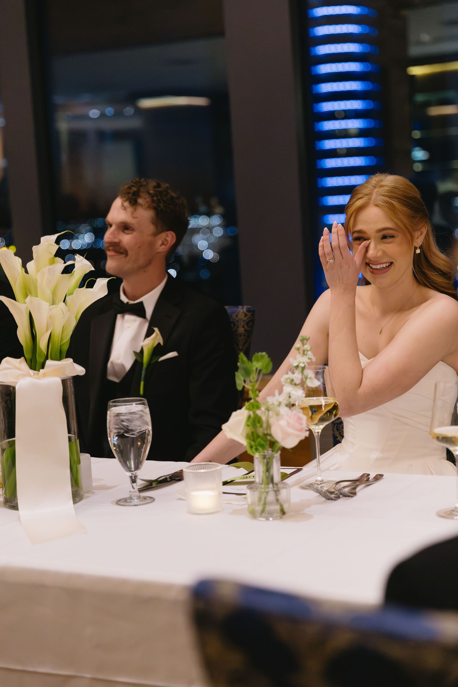 Reception table decorated with elegant white calla lilies and formal place settings.