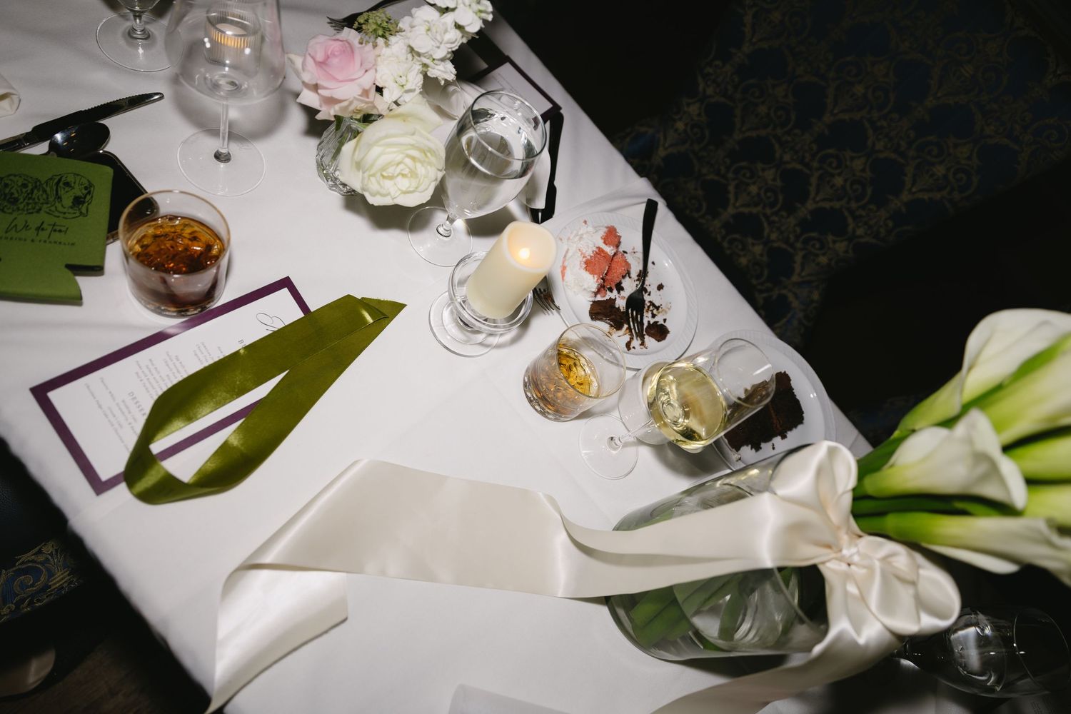 Elegant table settings with white linens and floral centerpieces at a wedding reception.