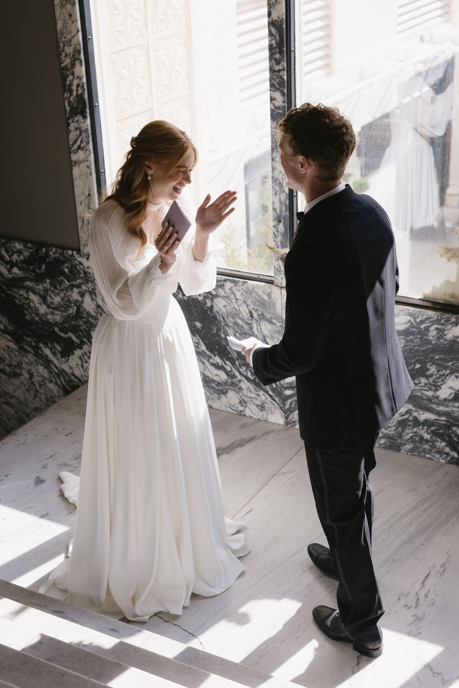 Wedding couple sharing a first look moment in a sunlit room.