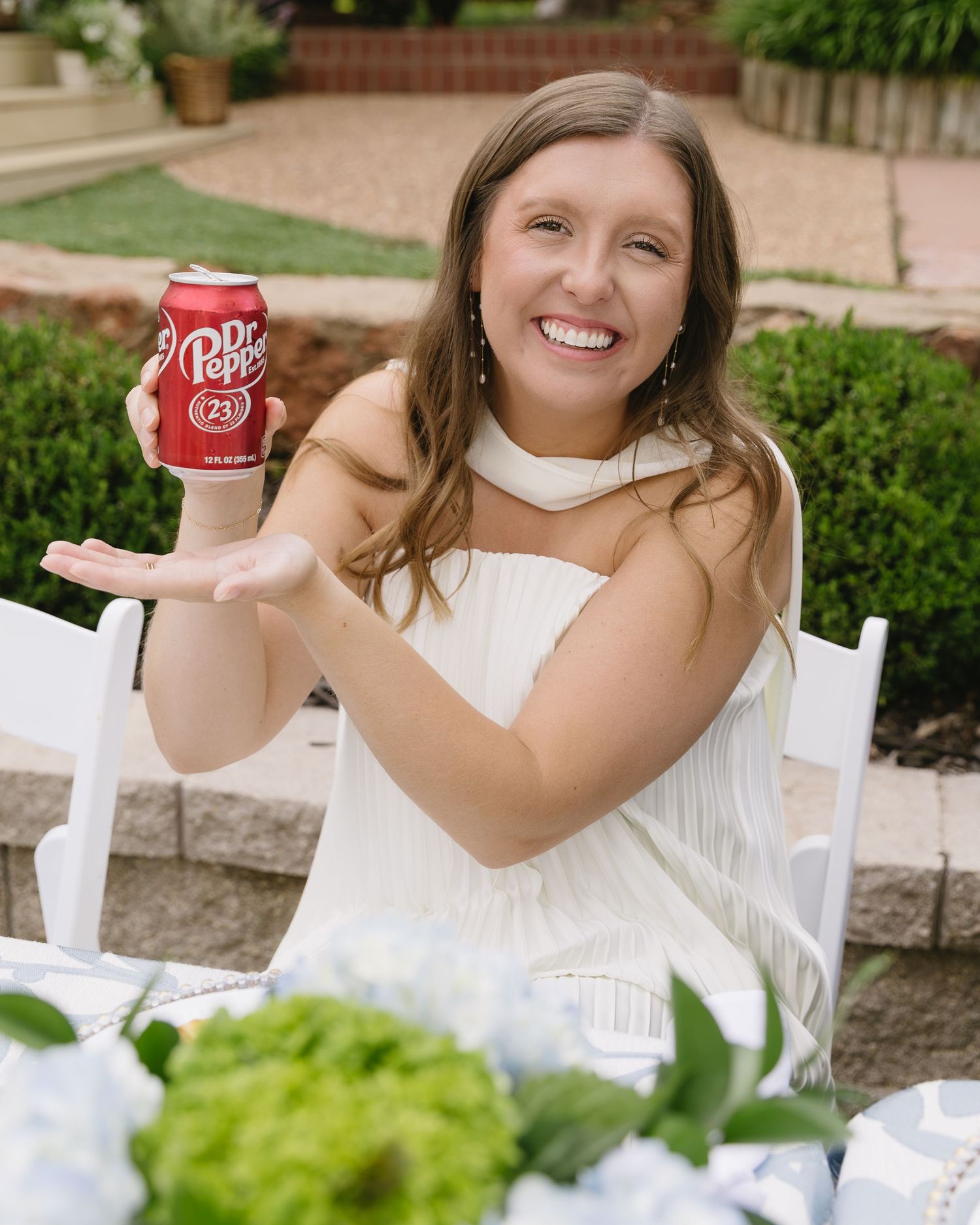 A festive outdoor gathering with white chairs and refreshments including Dr Pepper.