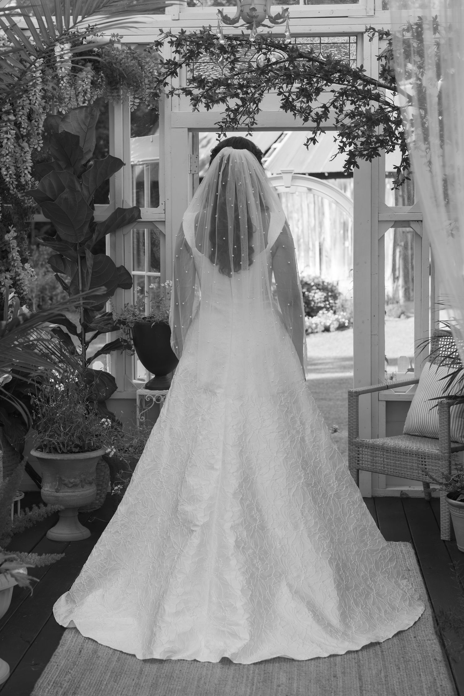 Wedding dress with voluminous skirt and lace details displayed in an indoor setting with sunlight streaming through windows.