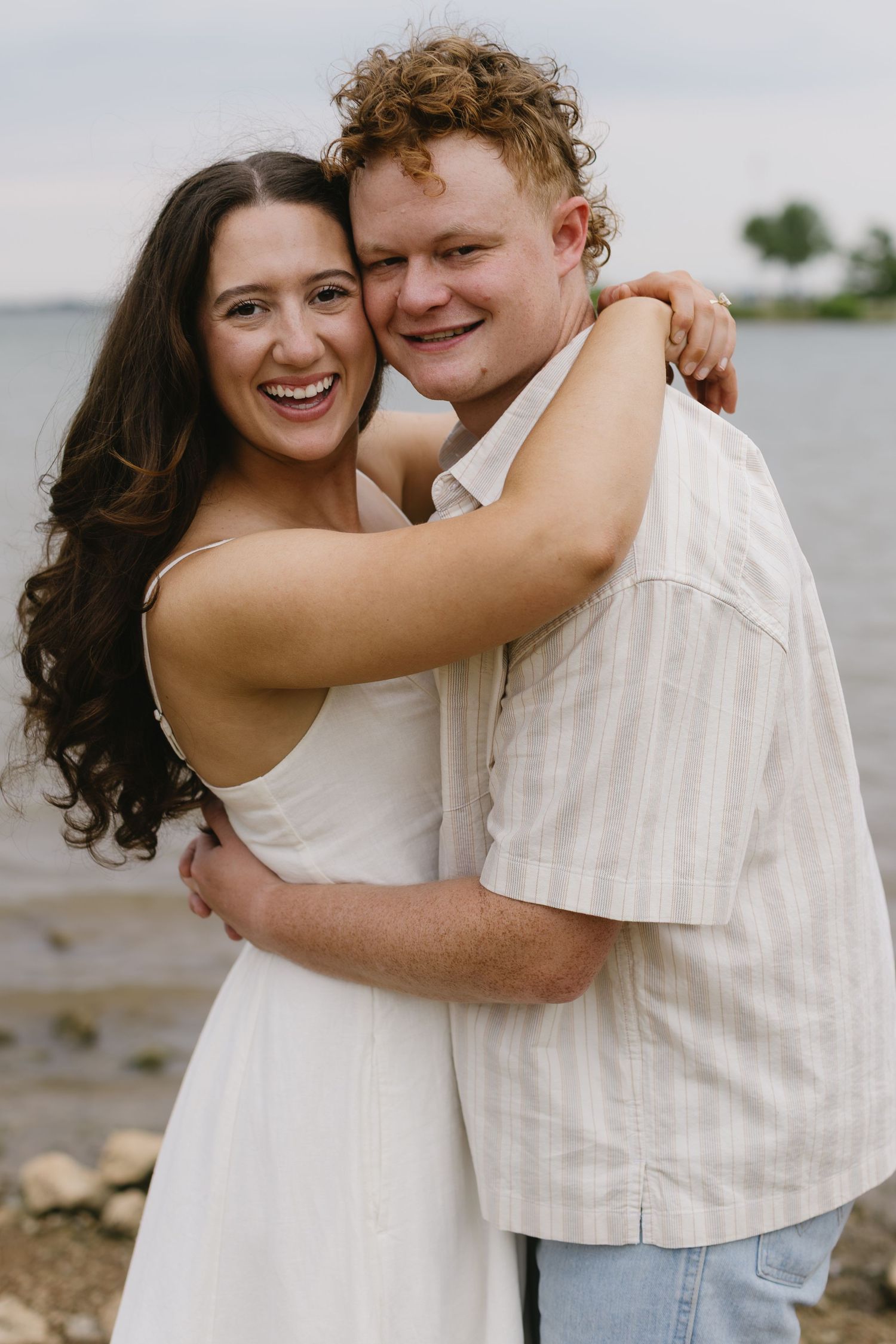 A series of candid moments showing a couple hugging and laughing together by the shore.