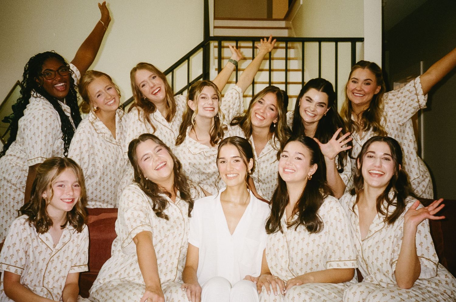 Wedding party members in matching robes celebrating together indoors.