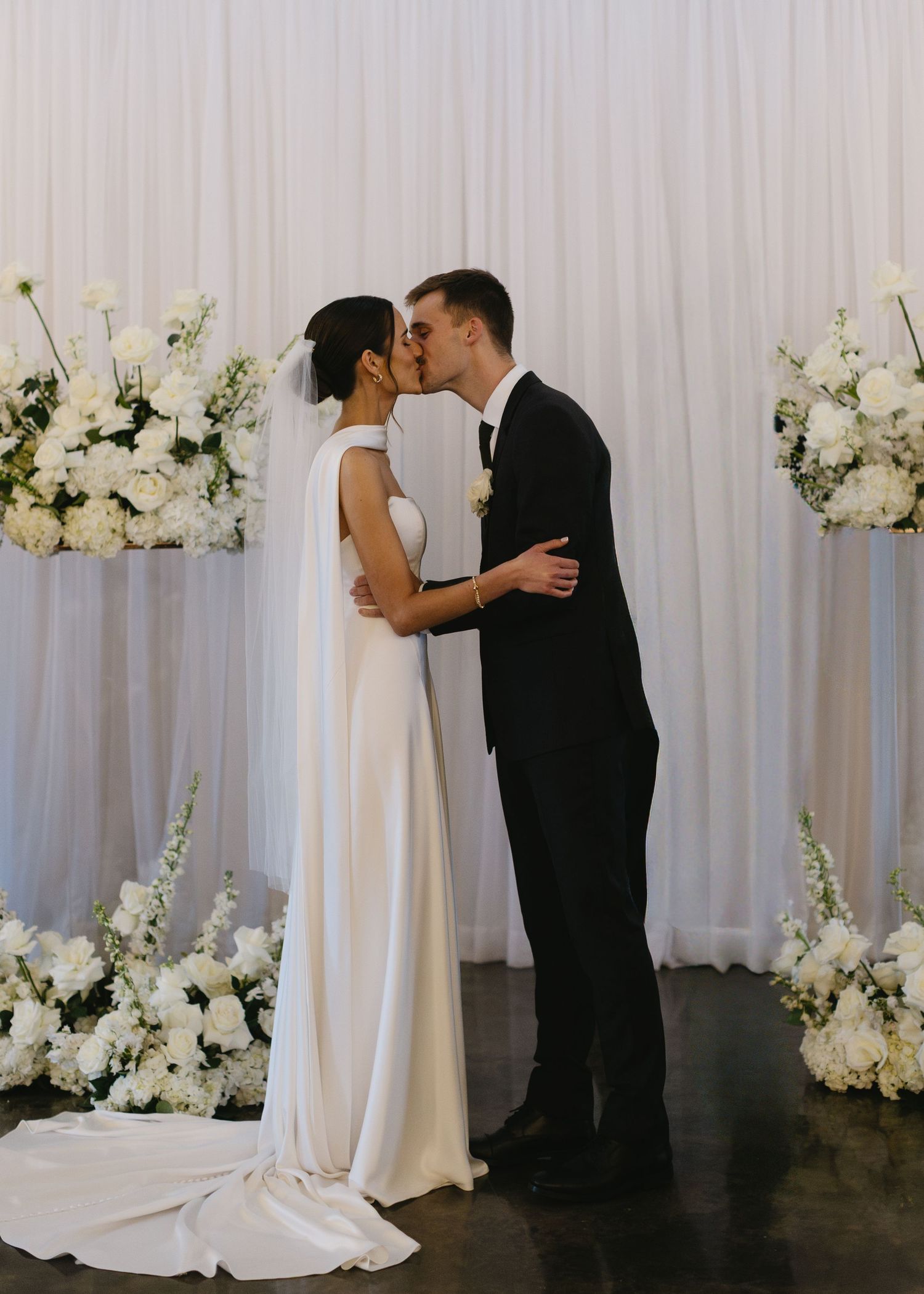 Wedding ceremony moments captured against a white backdrop with elegant floral decorations.