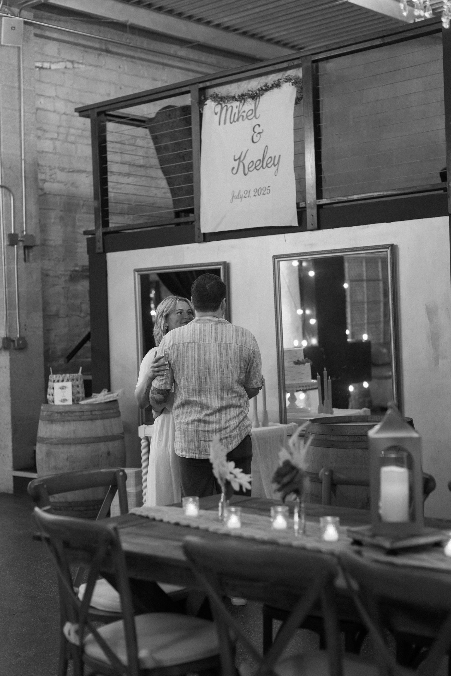 Guests seated at tables with candles in a dimly lit venue space.