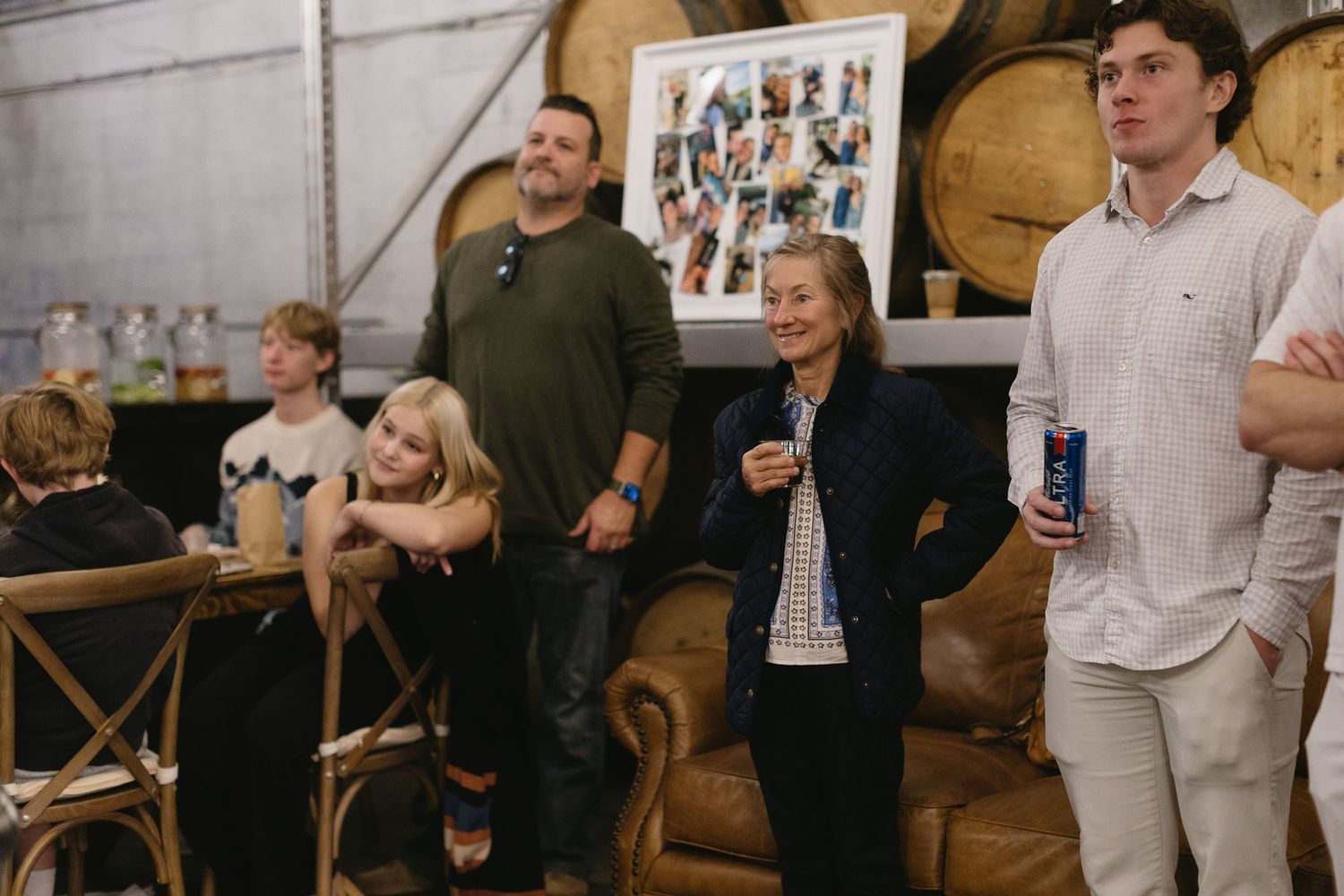 Group gathering in a rustic venue with wooden barrels and industrial decor.