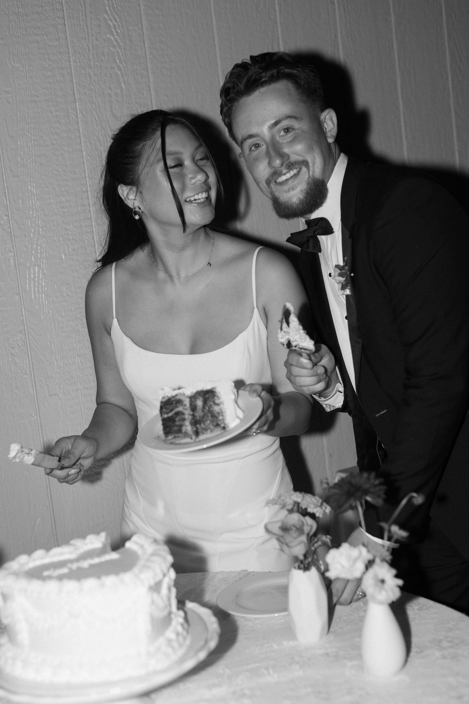 A series of black and white photos showing a couple cutting their wedding cake together.