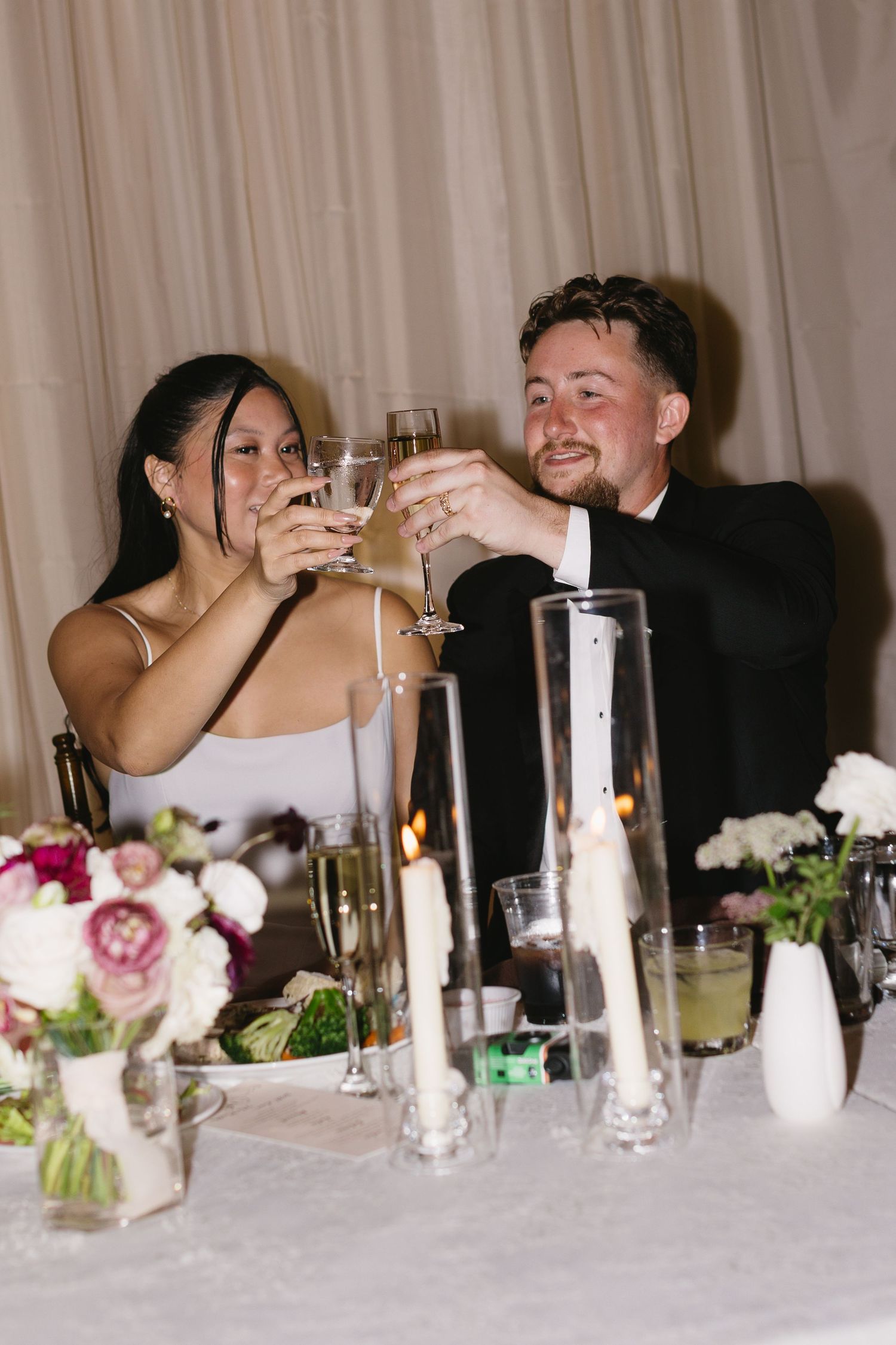 Wedding reception table with candles, floral centerpieces and champagne toast.