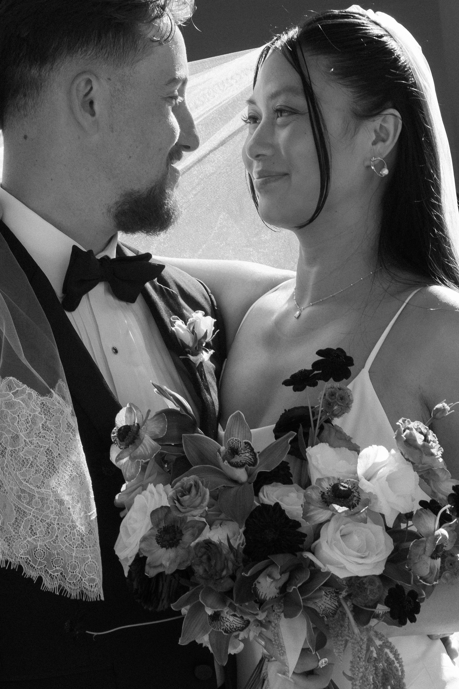 Close-up wedding photos showing tender moments between newlyweds with bridal bouquet of roses.