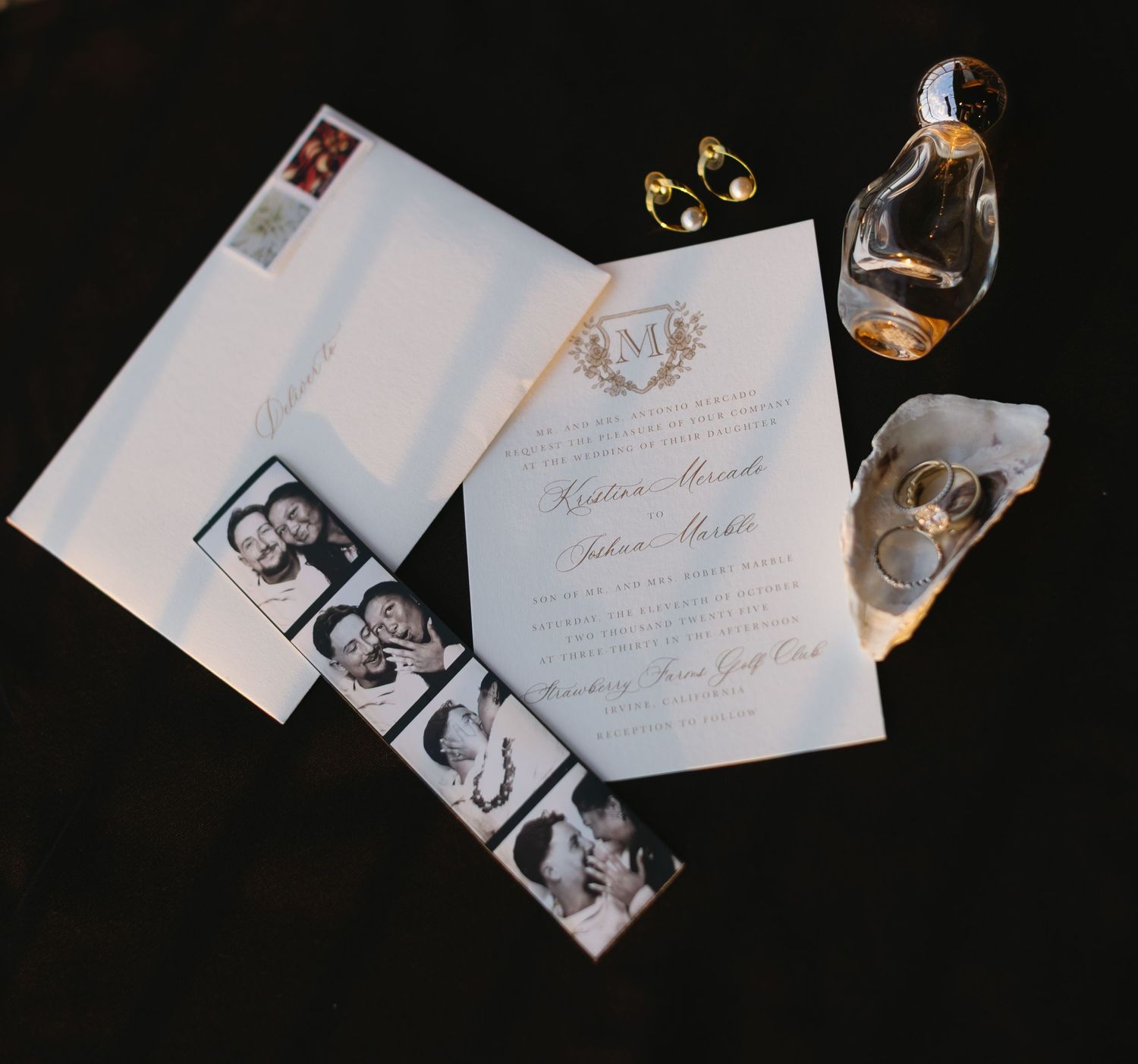 Wedding invitations and photographs arranged artistically on a dark surface.