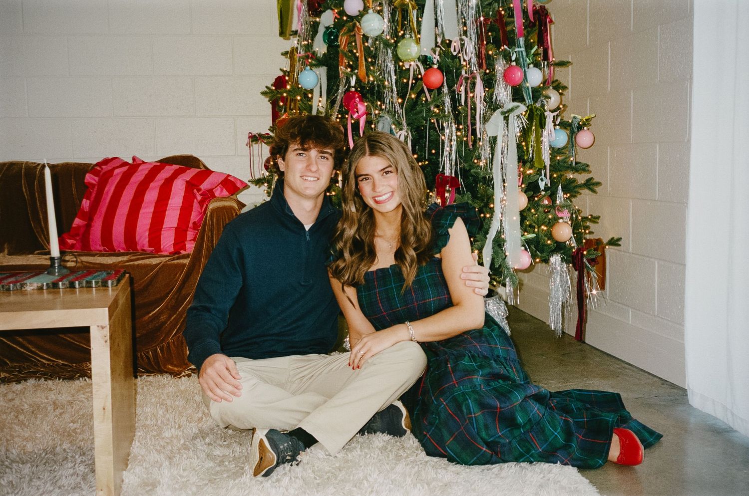 Festive holiday photos in front of a decorated Christmas tree with stockings and ornaments in a cozy living room setting.