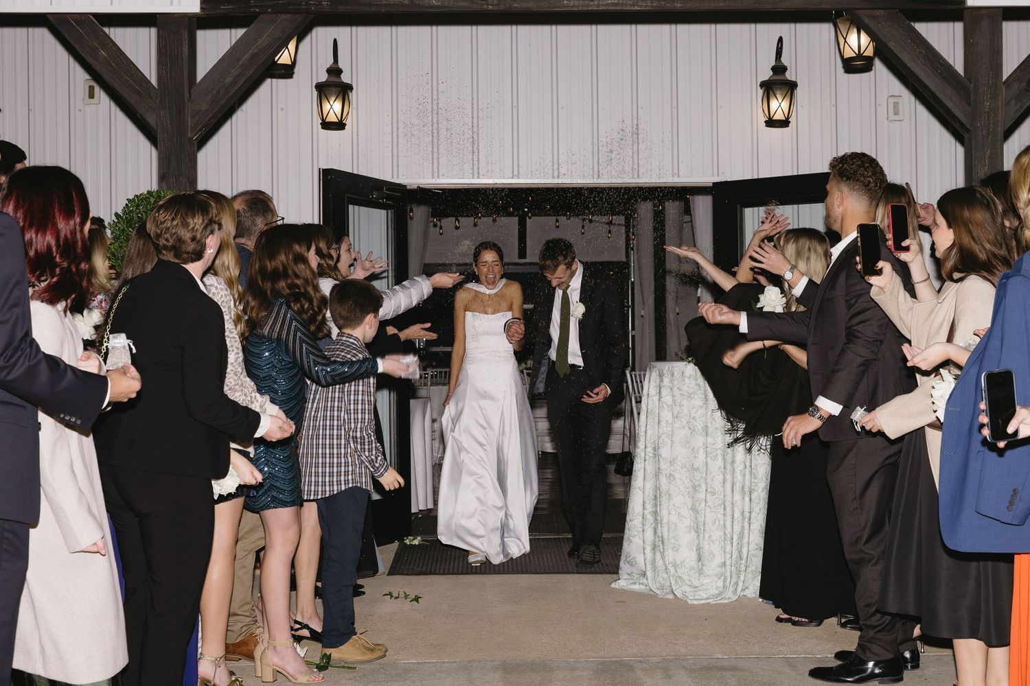 Wedding guests dancing and celebrating at an evening reception.