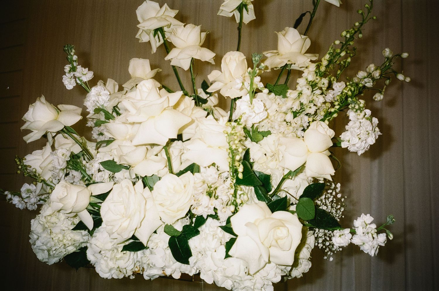 Elegant white floral arrangement with roses and delicate blooms in classic design.