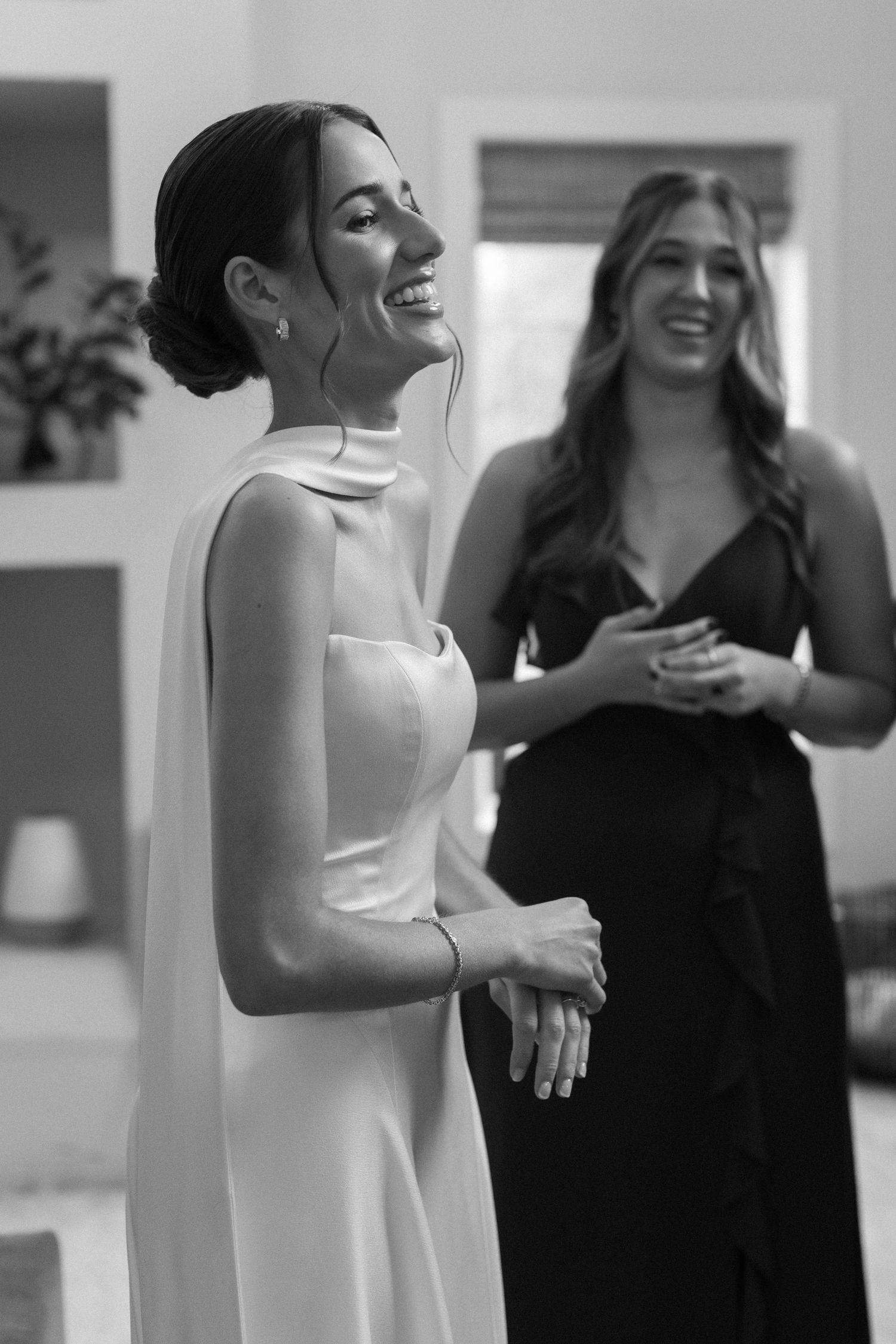 Two people share a joyful moment during wedding preparations indoors.