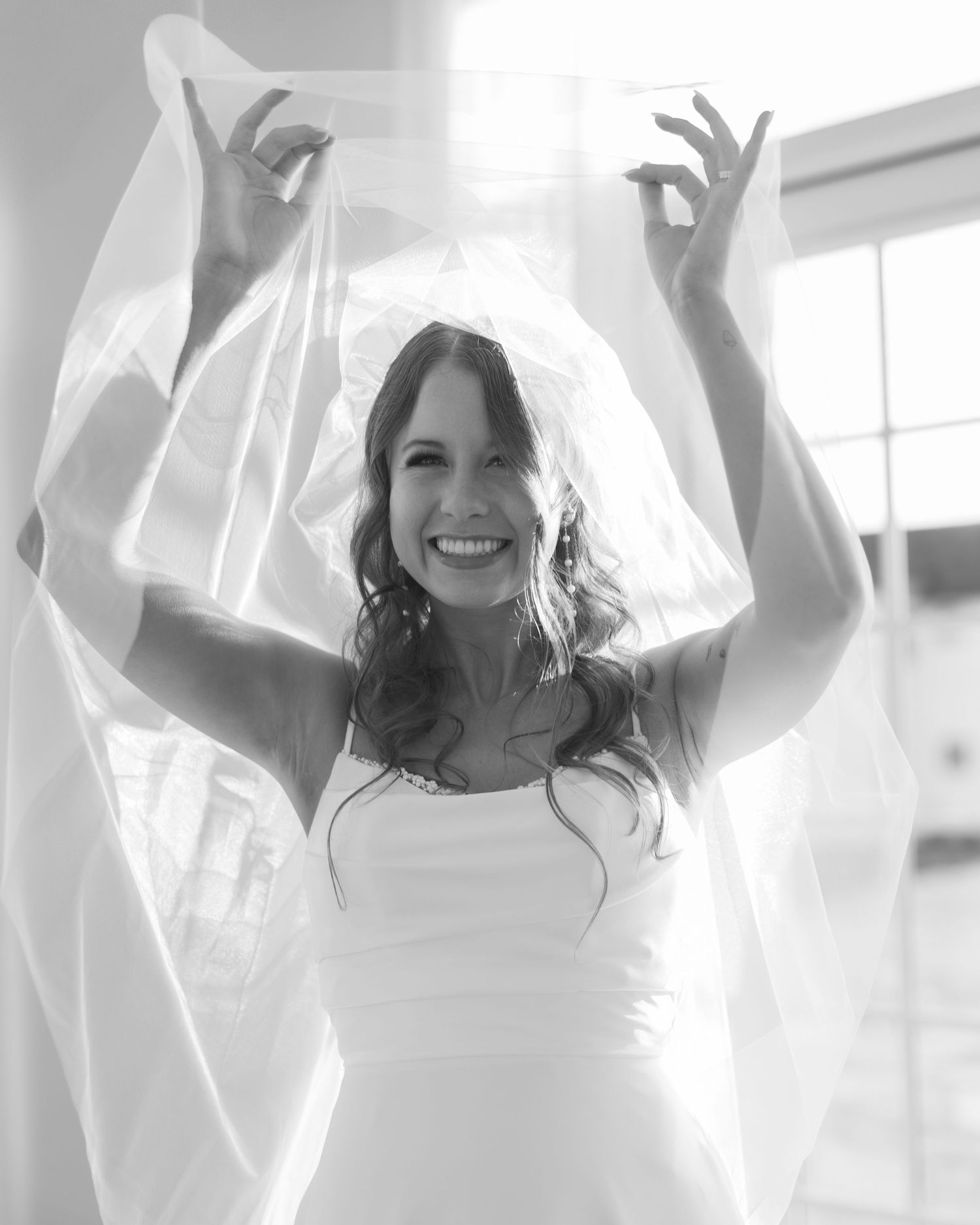 A collection of joyful figures in white dresses raise their arms in celebration against a bright background.