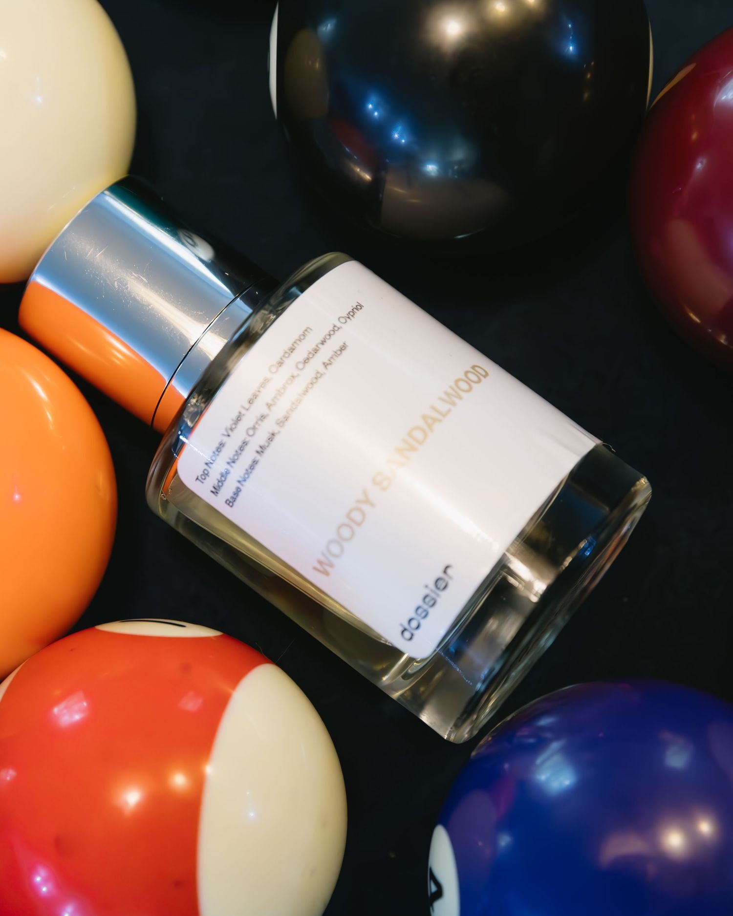 Colorful balloons and perfume bottles arranged against a dark background.
