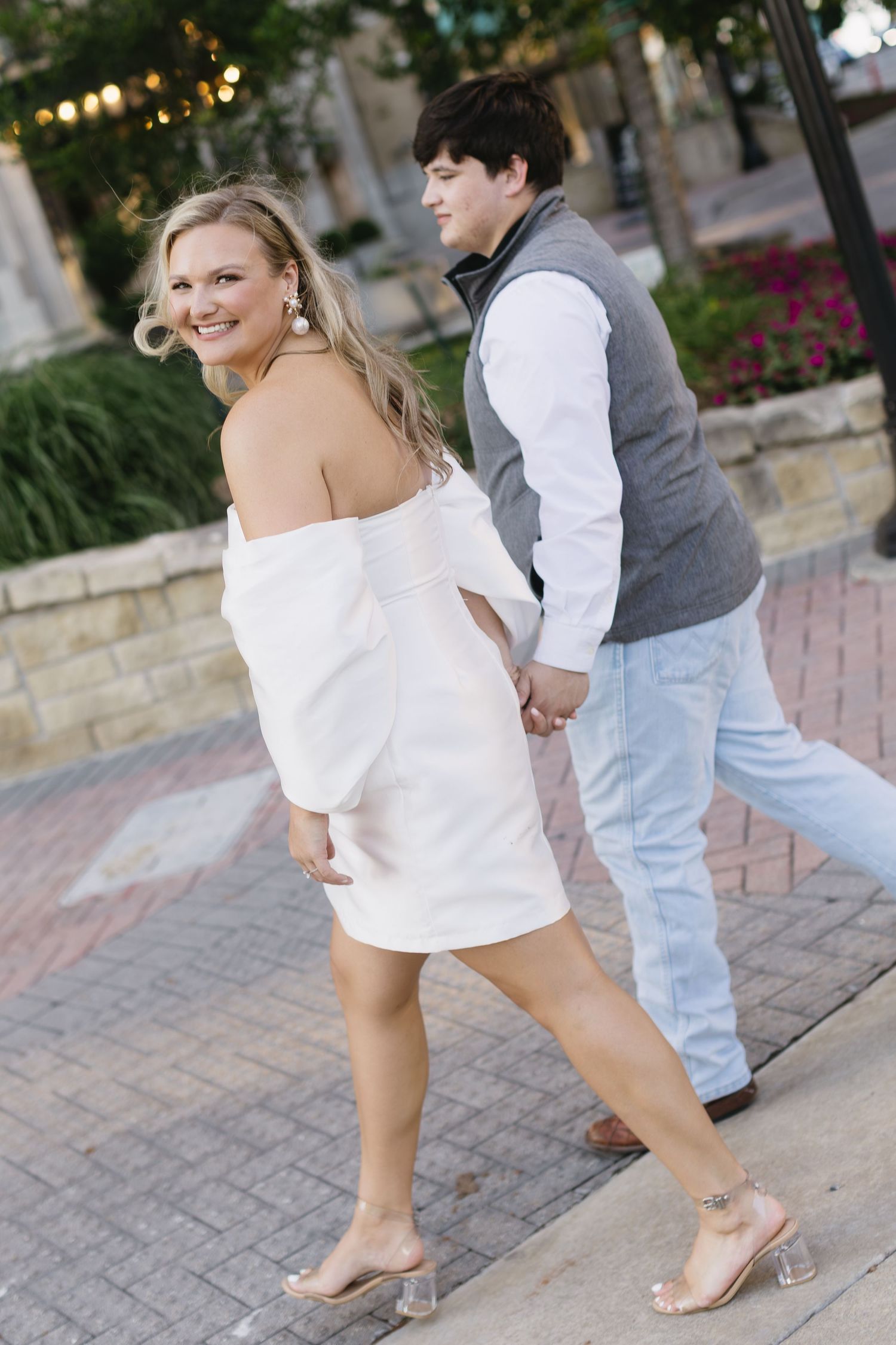 Close-up sequence of feet moving in dance steps on a stone patio with party lights in the background.