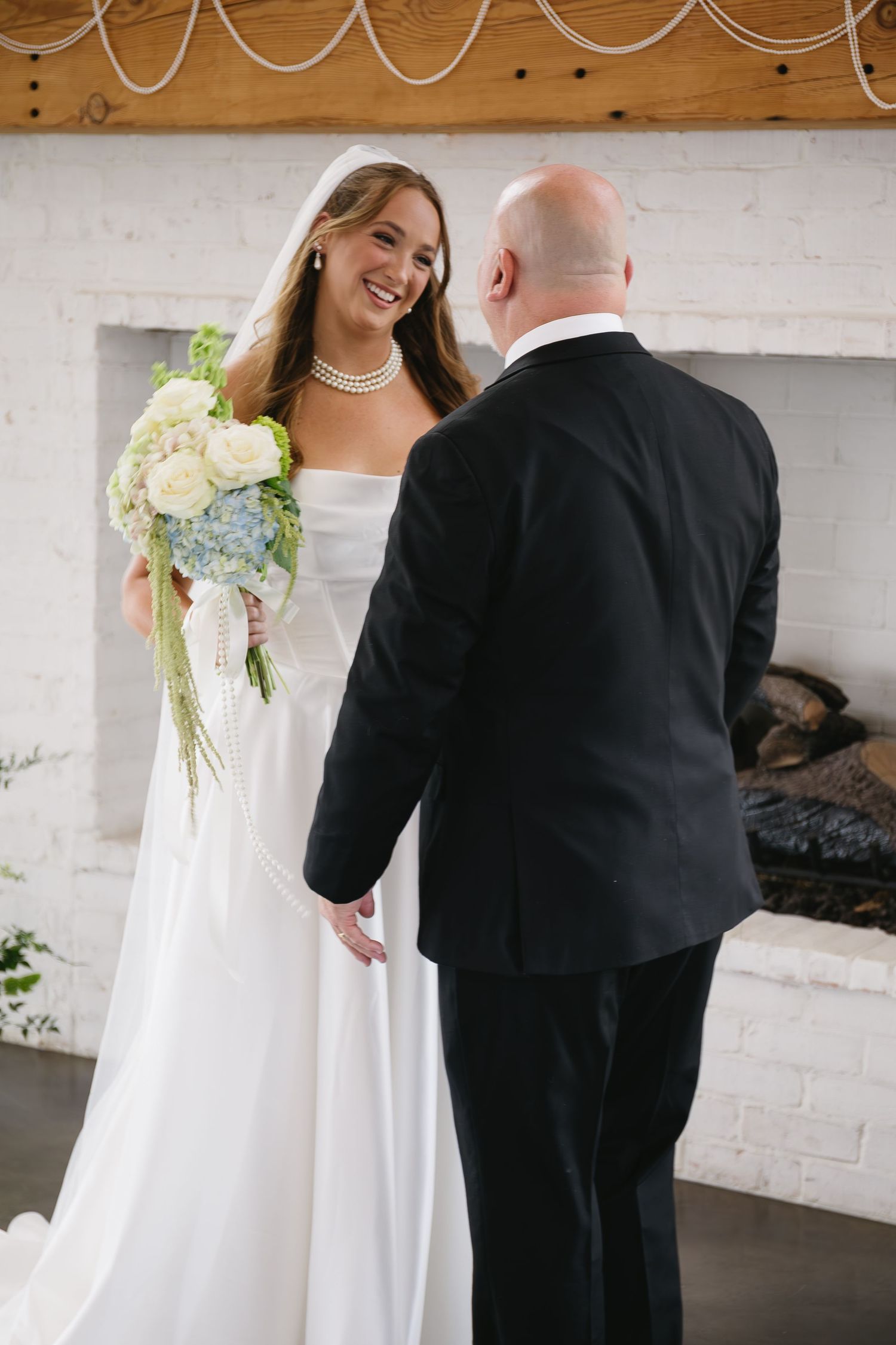 Emotional first look sequence between bride and groom in a rustic indoor venue.