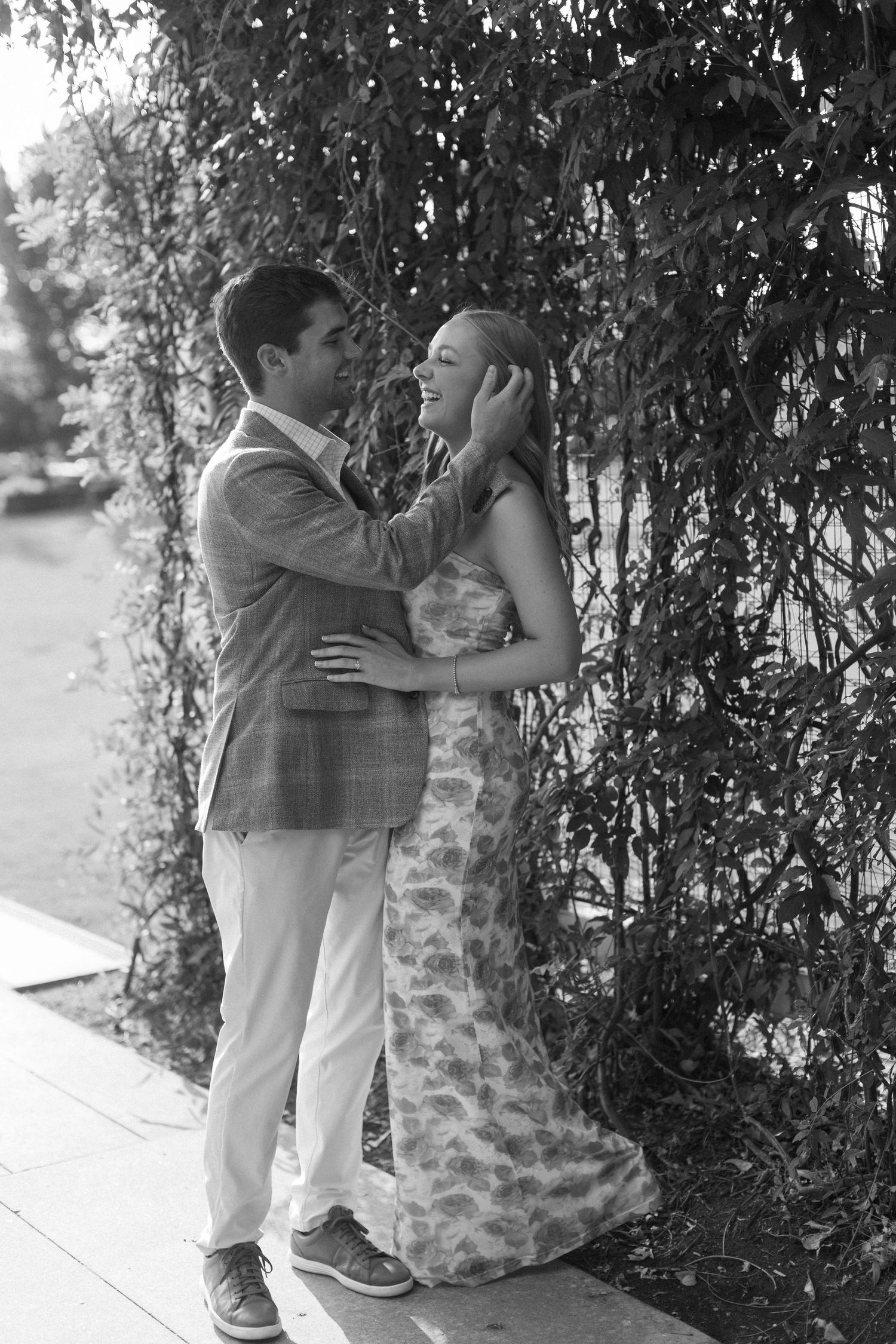 A couple shares an intimate moment under hanging vines in a romantic black and white photoshoot sequence.