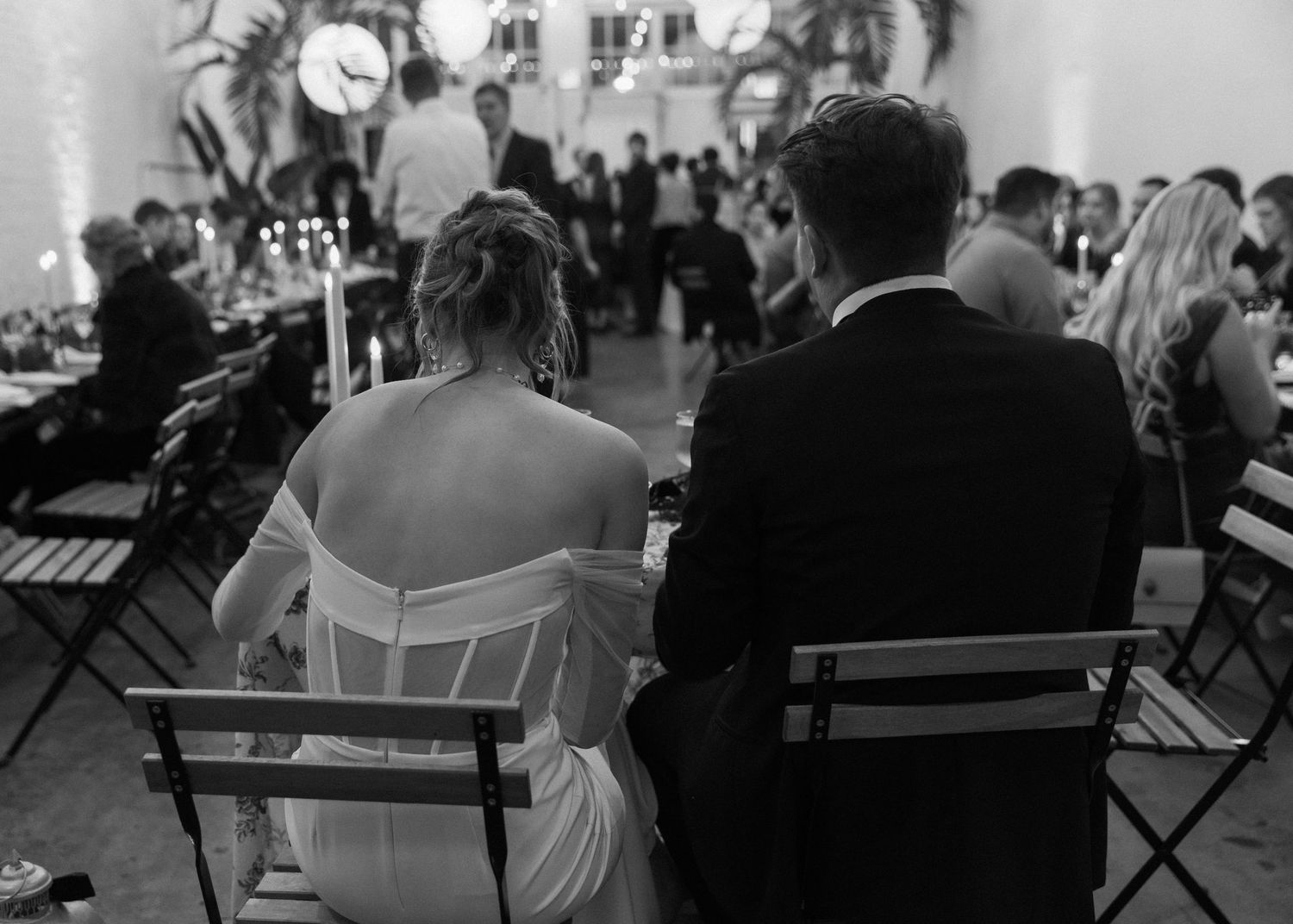 Black and white photo of wedding guests seated in rows during an outdoor ceremony.