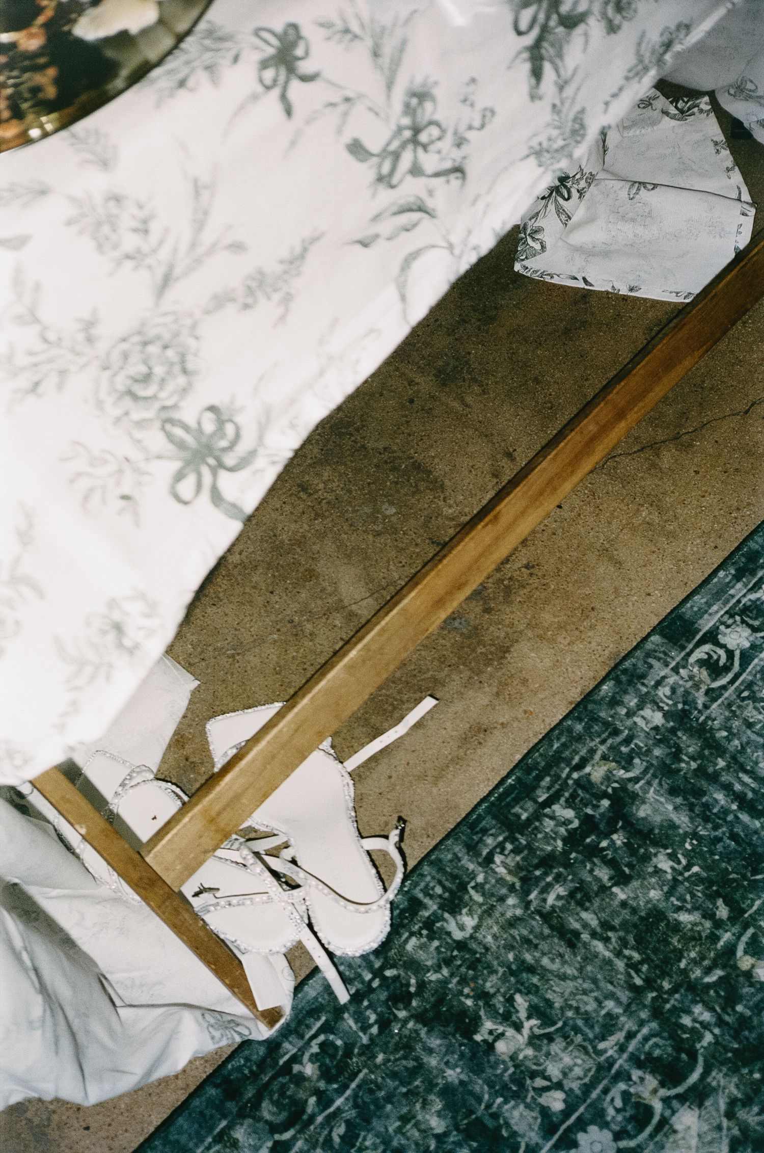 White patterned wallpaper and wooden floor detail in an interior setting.