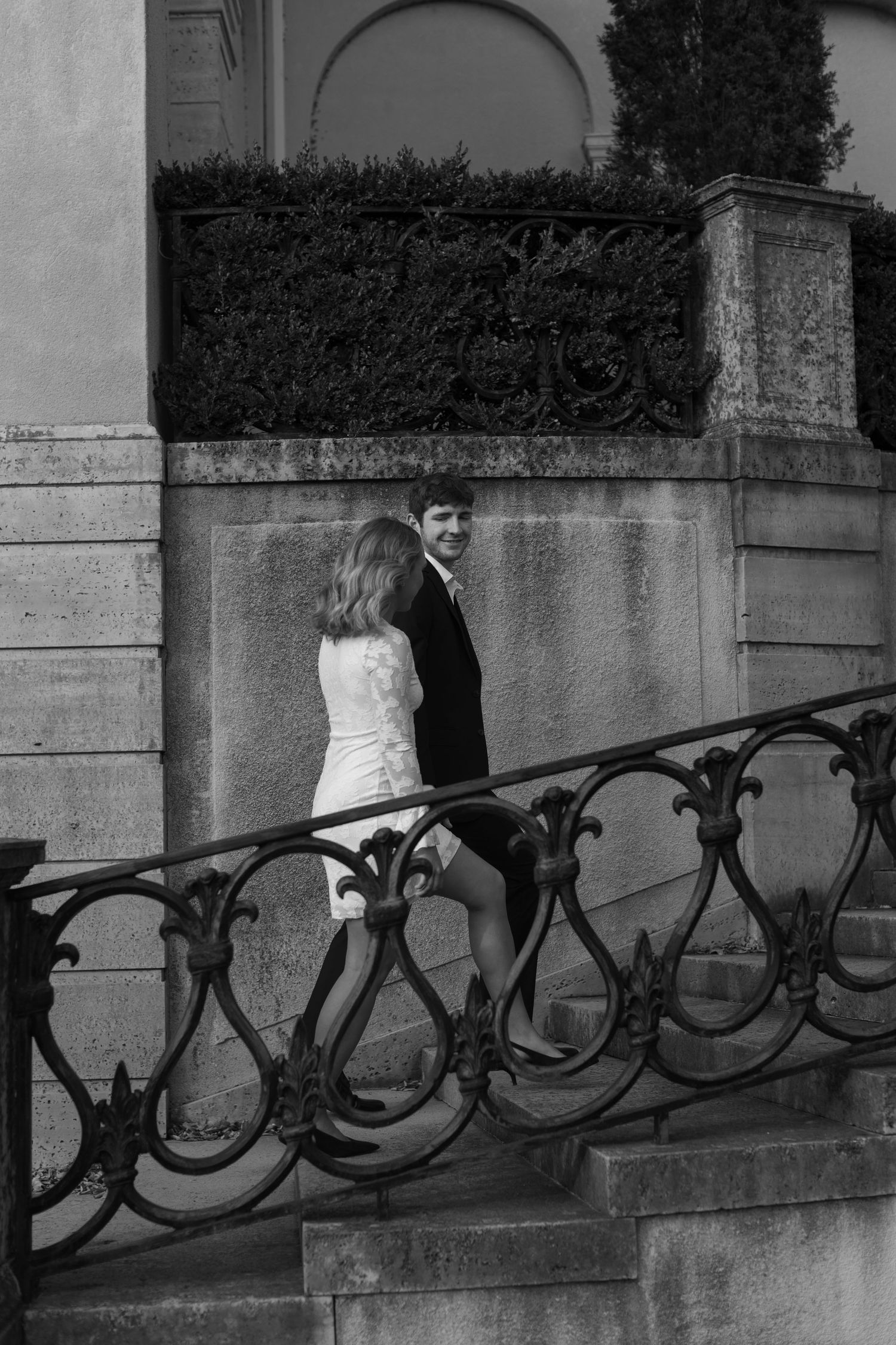 A series of artistic black and white photos featuring a couple by an ornate iron railing.