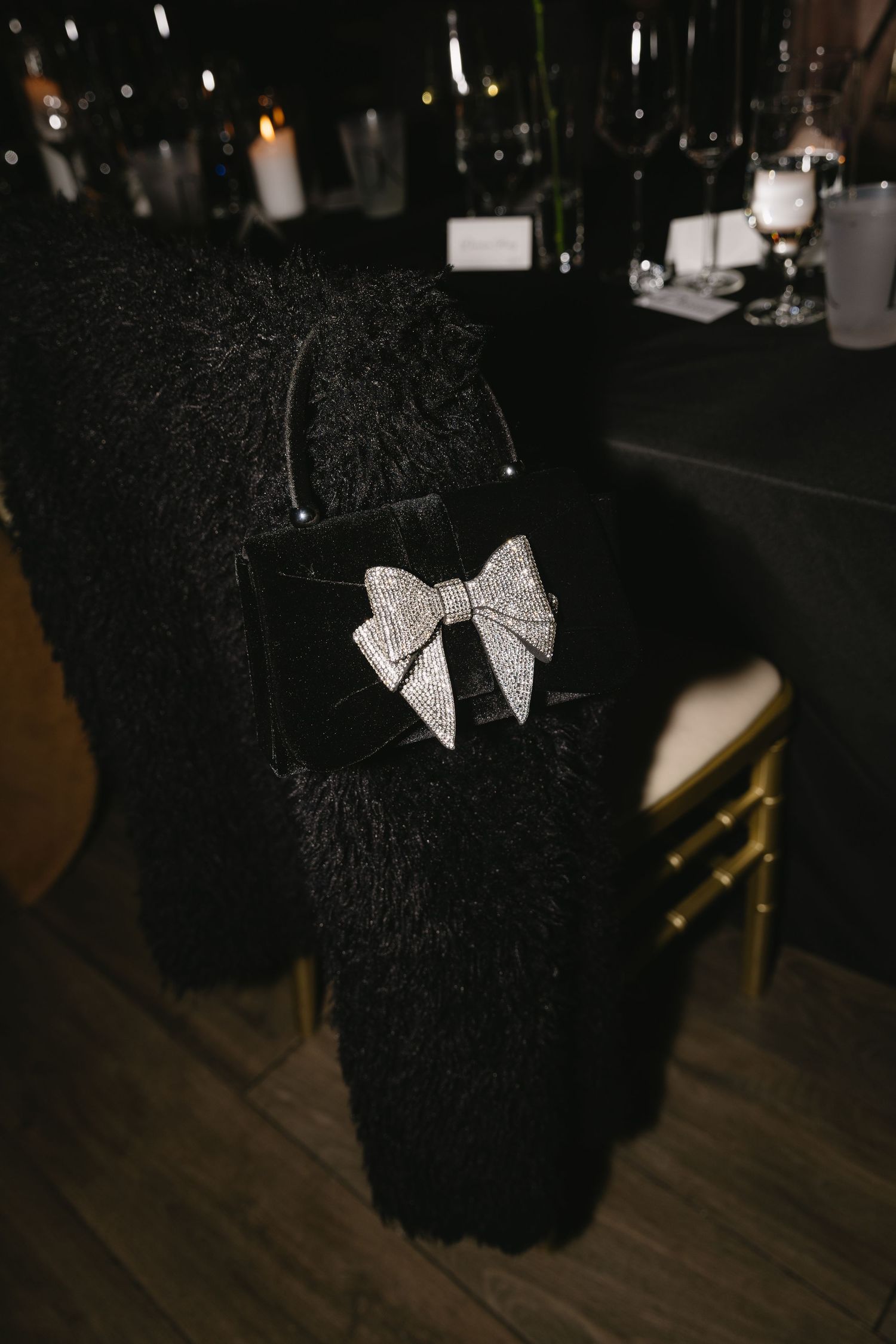 Decorative silver bows on black fabric at formal event.