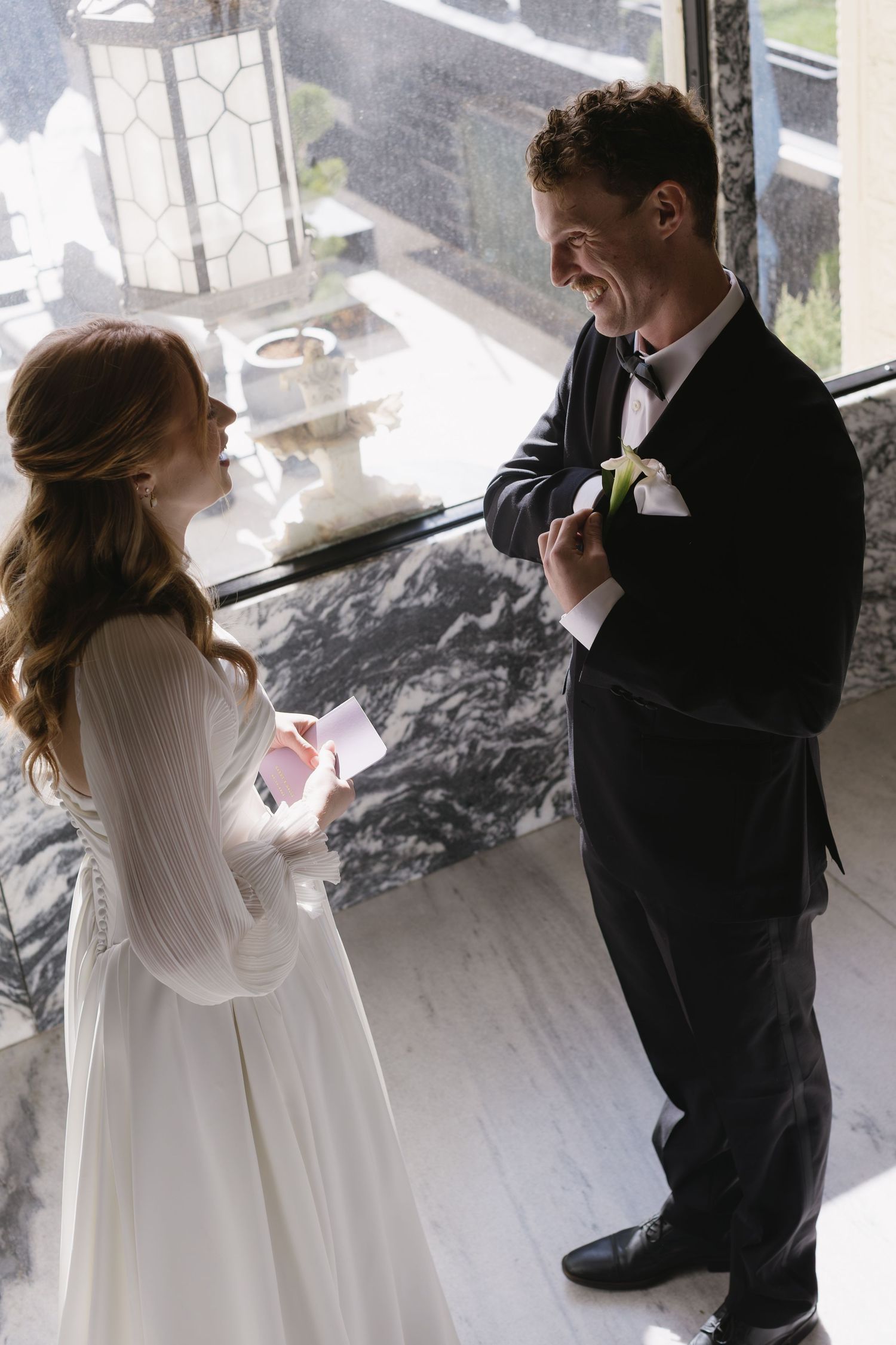 Intimate wedding photography sequence near a sunlit window in an industrial space.