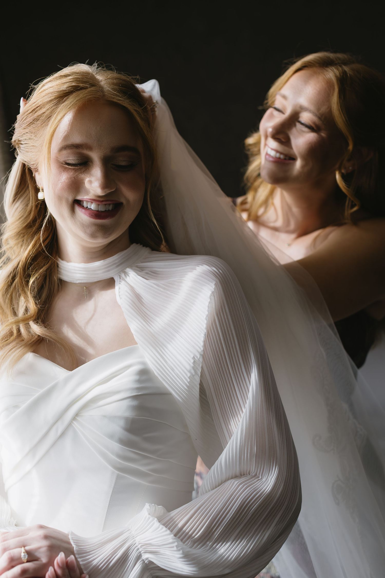 Ethereal bridal portraits in flowing white gown against dark background.