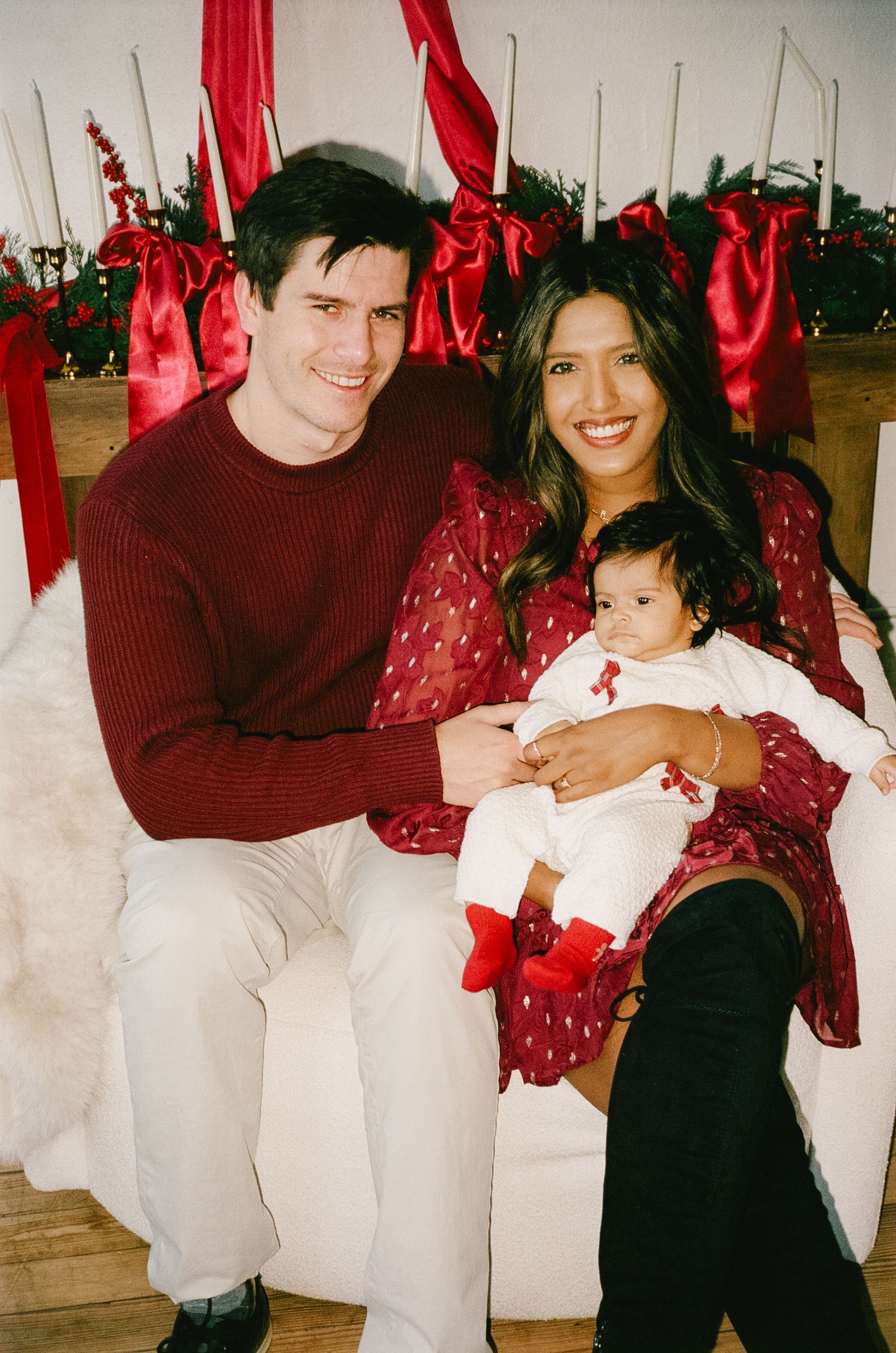 Cozy family holiday photos with red decorations and matching burgundy outfits.