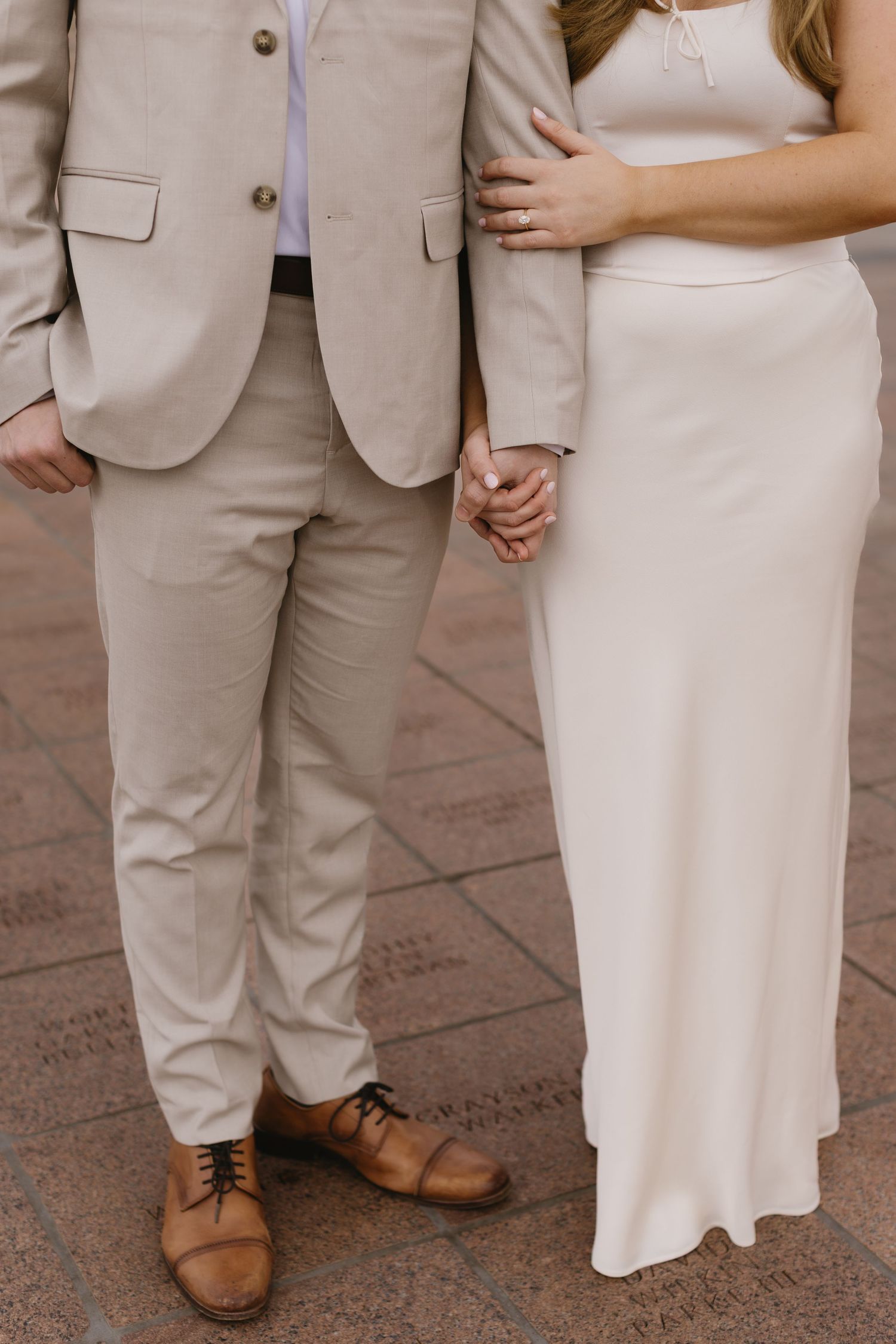 Close-up details of formal outfits showing a beige suit and white dress with brown shoes.
