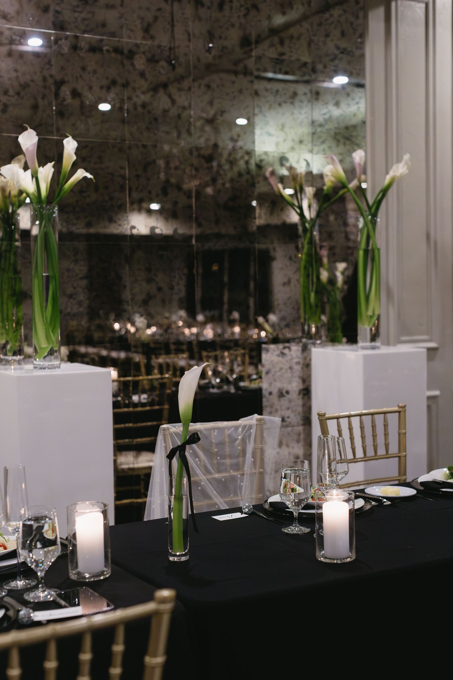 Elegant wedding reception tables with calla lily centerpieces and white chiavari chairs.