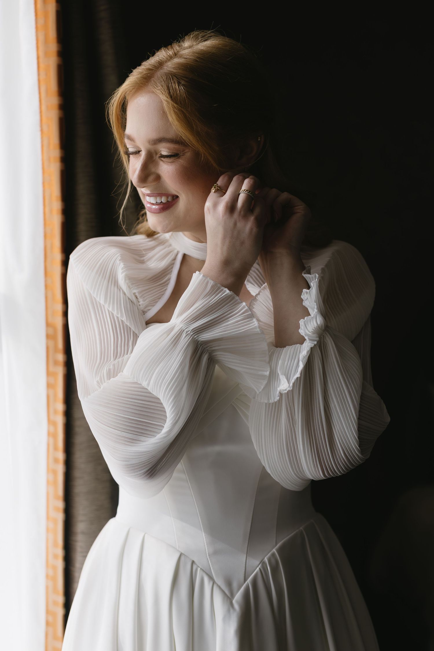 Artistic bridal portraits featuring flowing white dress with pleated sleeves in natural light.