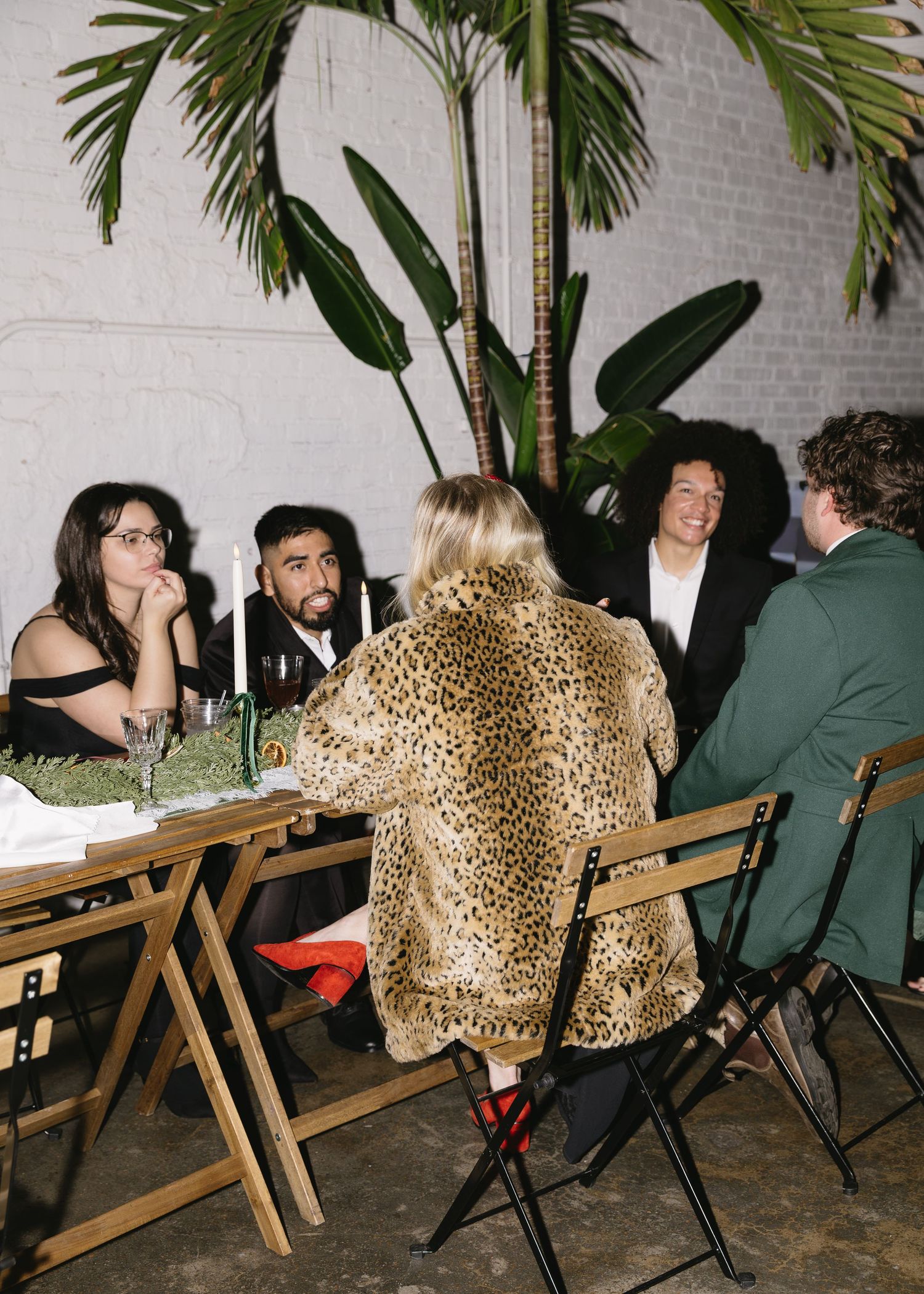 Wedding reception seating with leopard print cushions and tropical palm decor.