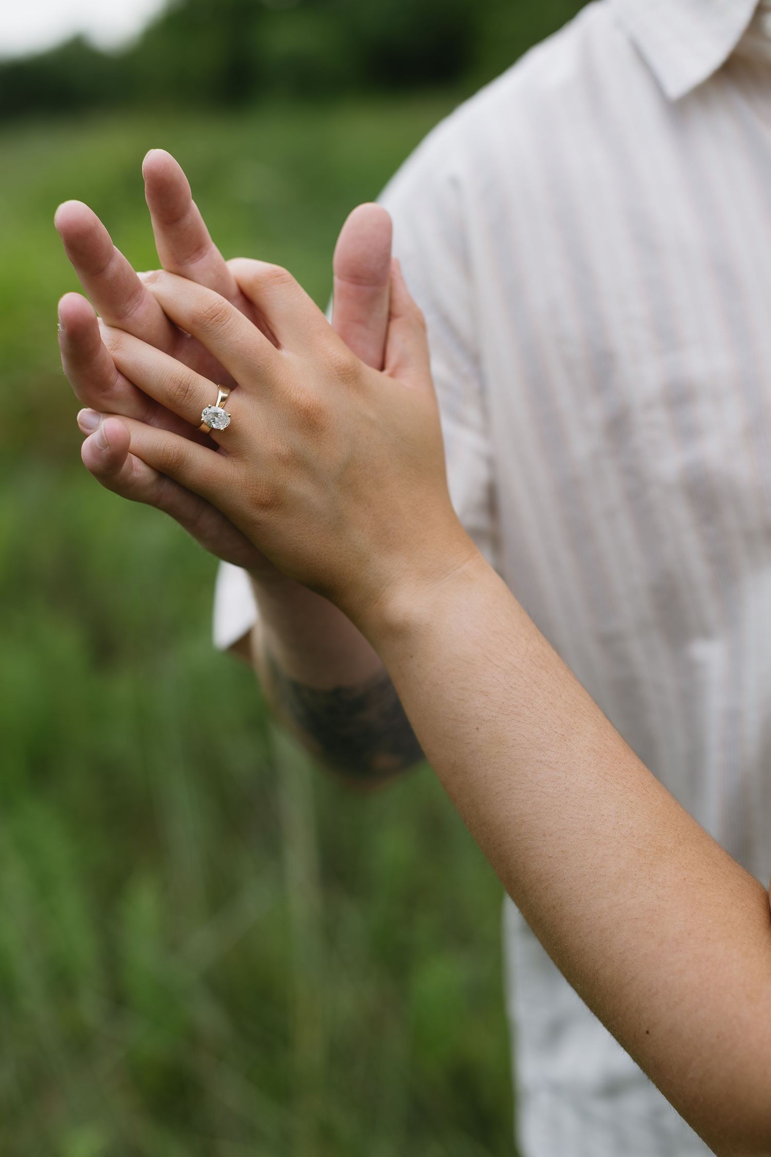 Close-up shots of hands with engagement rings entwined against a natural outdoor background.