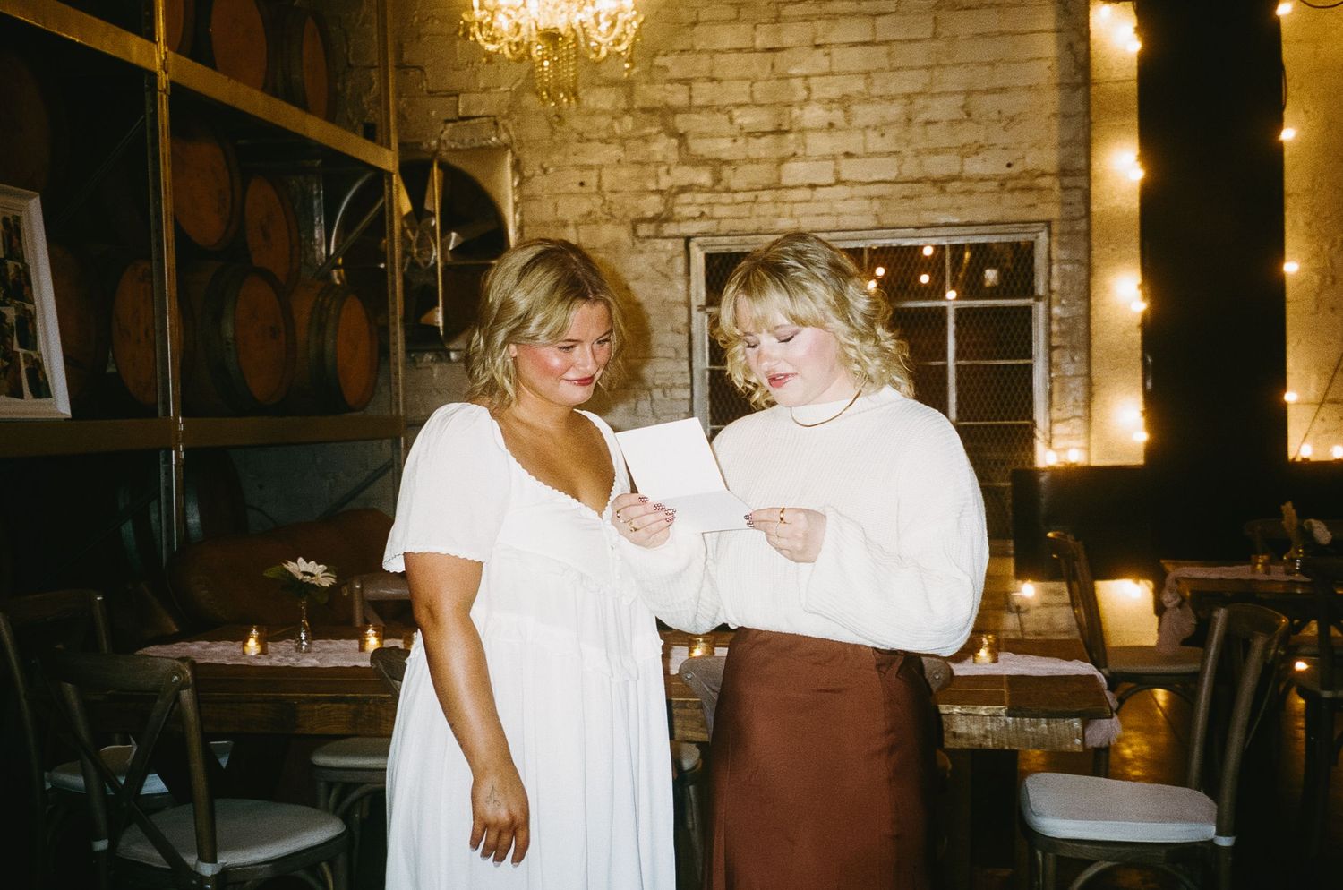 Couple enjoying a casual moment together in a rustic brick-walled venue.
