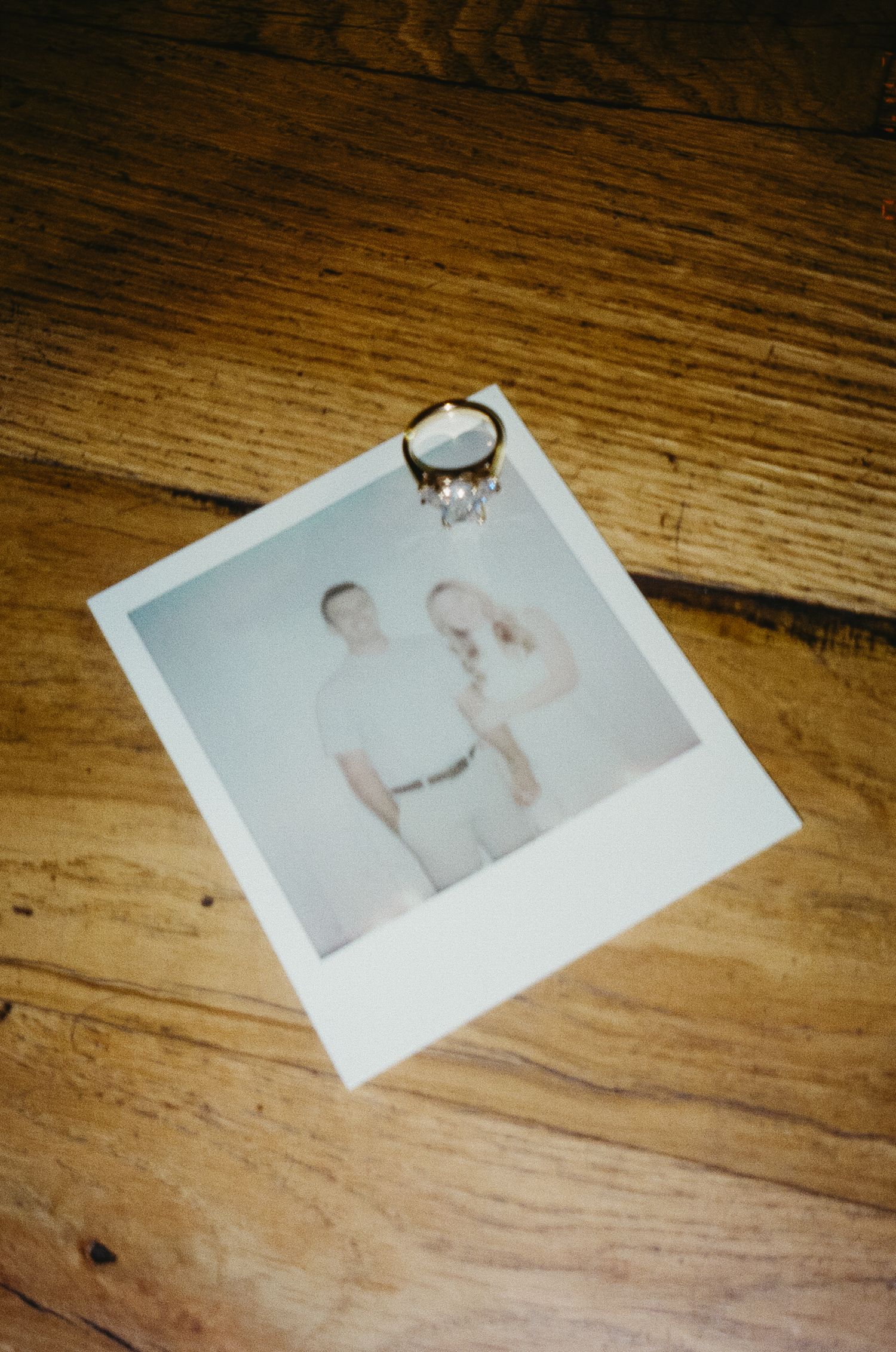 A series of polaroid photos laid out on a wooden floor in sequence.