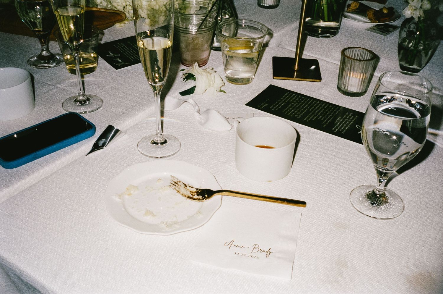 Wedding reception place setting with champagne glasses and elegant table decor.