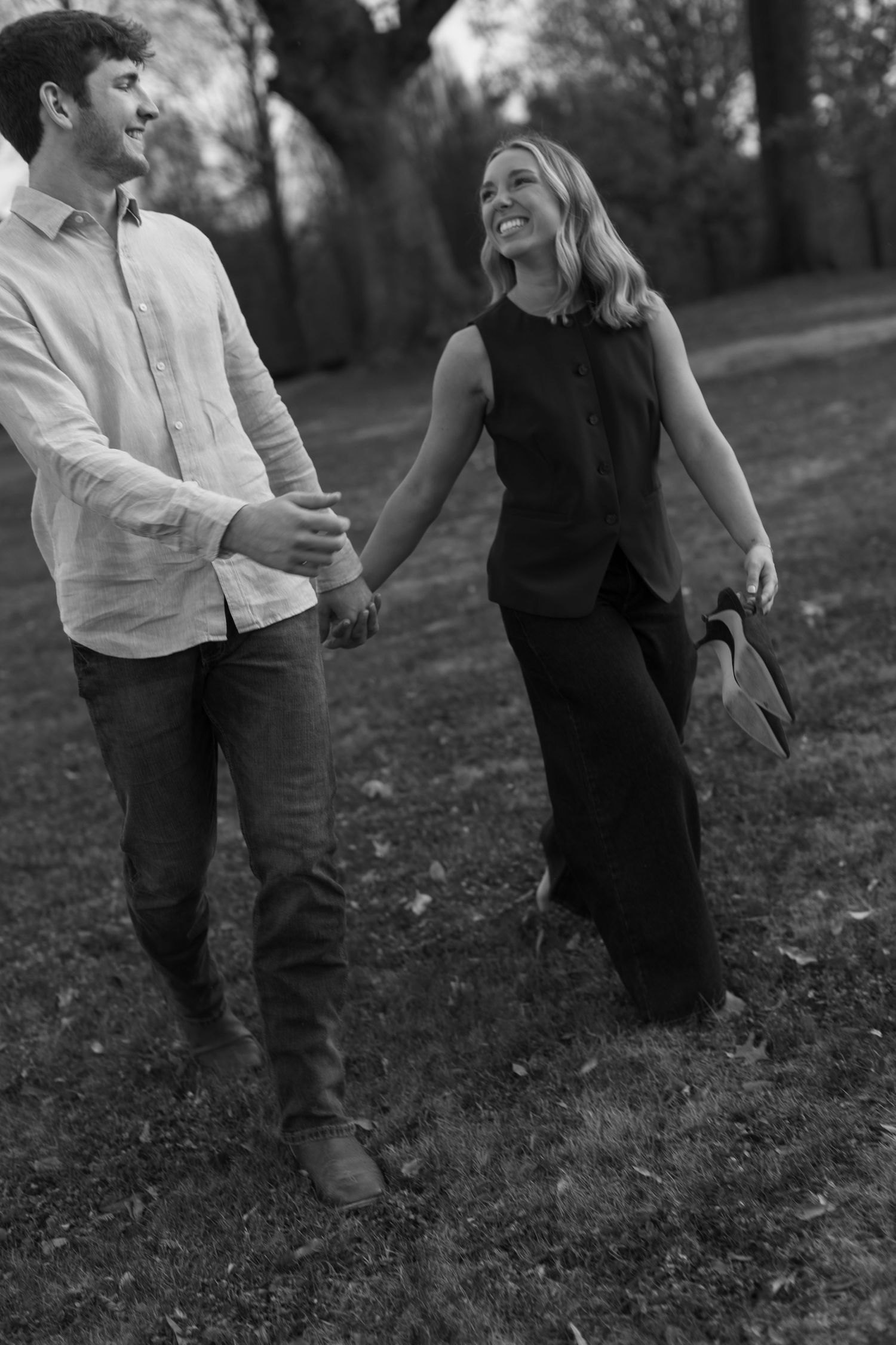 Black and white photo series showing a couple walking and embracing in a grassy outdoor setting.